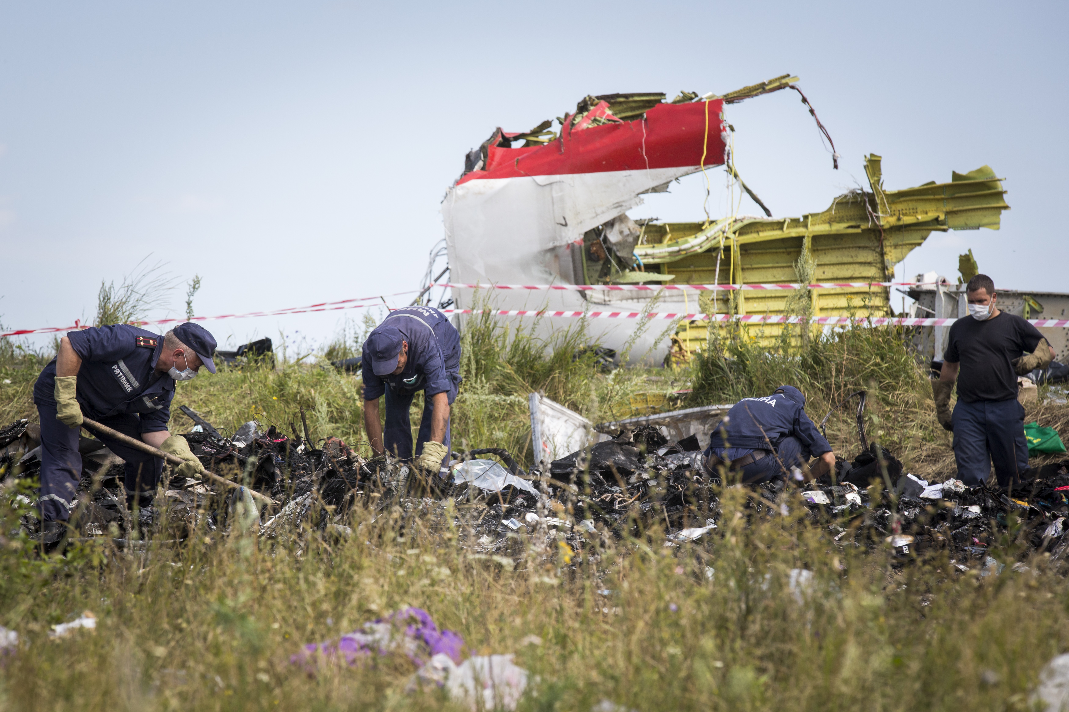 Ukrainian rescue servicemen look through the wreckage of Malaysia Airlines flight MH17 on July 20, 2014 in Grabovo, Ukraine. (Rob Stothard—Getty Images)