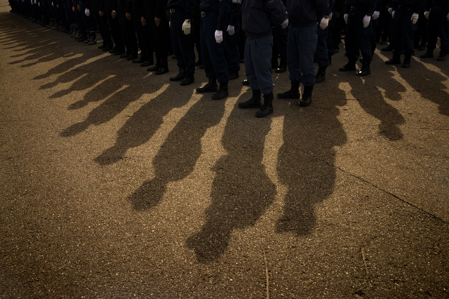 Japan, Namie, 2014Police officers stand in formation after looking for bodies inside the nuclear zone around the crippled Daiichi Nuclear Plant the day before the third anniversary of the earthquake and Tsunami that hit the north east coast of Japan in 2011.