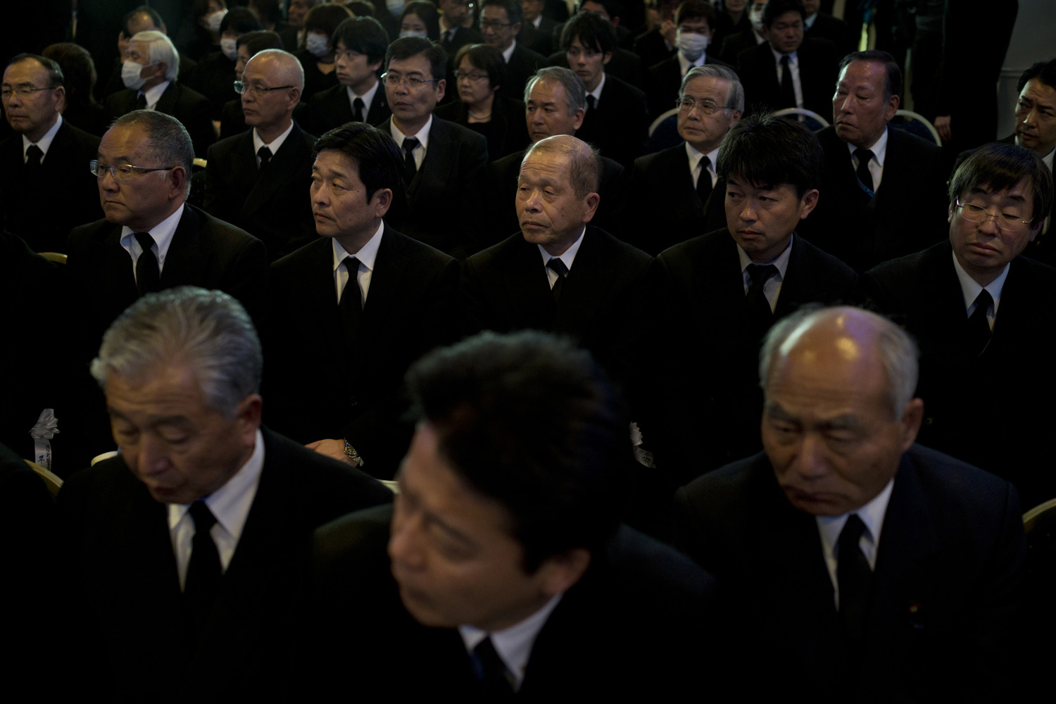 Japan, Namie, 2014. Residents from Namie attend a memorial service on the third anniversary of the earthquake and tsunami, which hit the northeastern coast of Japan in March 2011. The ceremony is held inside the 20- kilometer exclusion zone around the crippled Fukushima Daiichi Nuclear Power Plant.