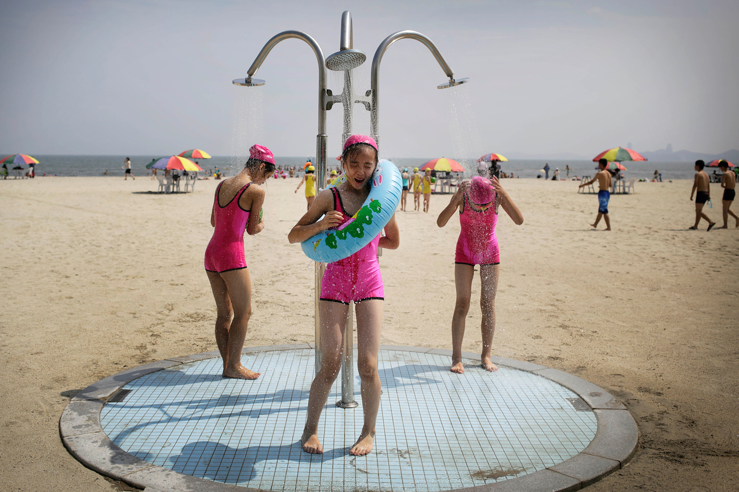 North Korean girls in similar bathing suits stand under a shower at the Songdowon International Children's Camp, Tuesday, July 29, 2014, in Wonsan, North Korea. (Wong Maye-E –AP)
