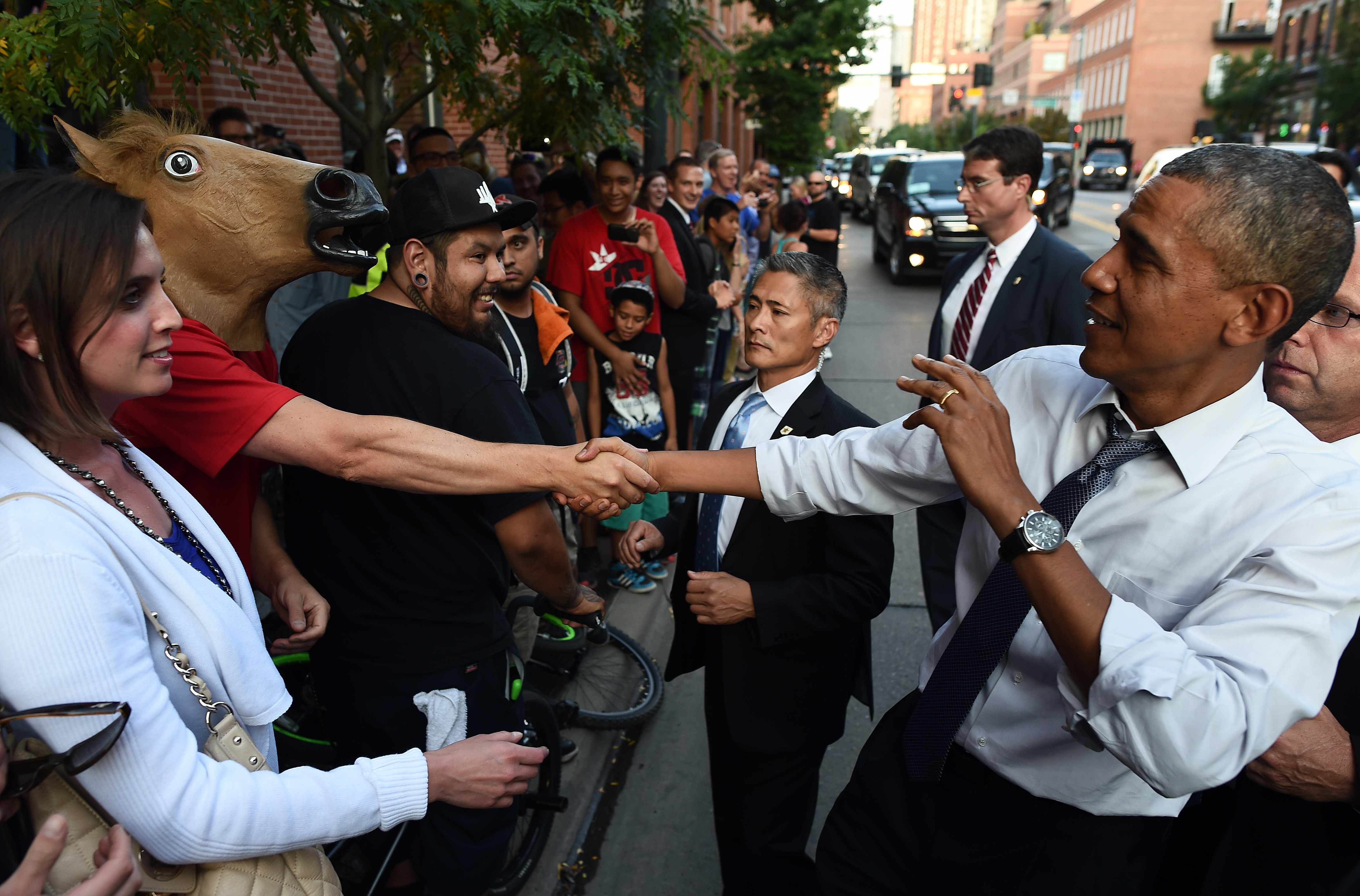 President Obama jokingly reacts as he shakes hands with a man wearing a horse head mask on a street in Denver, Colo., on July 8, 2014. (Jewel Samad—AFP/Getty Images)
