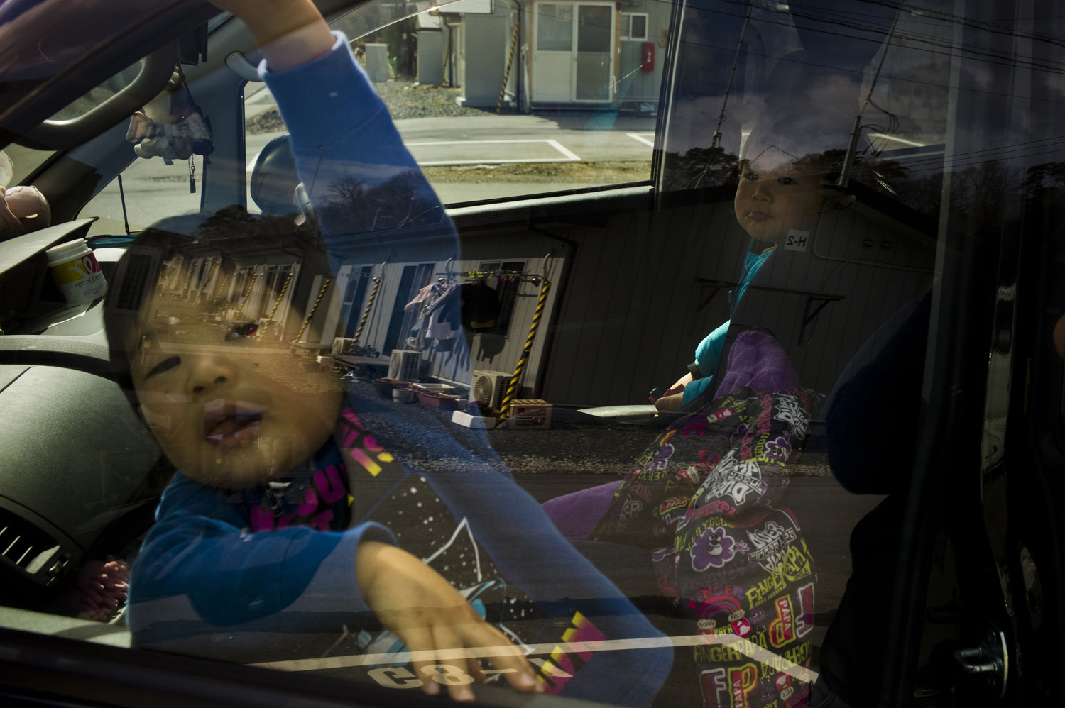 Japan, Iwaki, 2014. Young evacuees from Naraha in temporary housing units. Riku (3) and Sara (2) wait for their parents Takumi and Mayumi Kitazawa (not pictured) to arrive before going shopping.