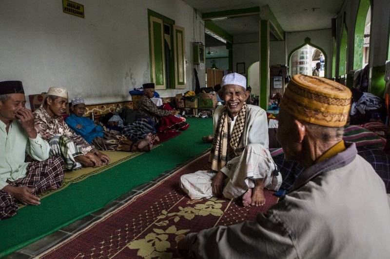 Elderly men talk to each other as they take a break at a boarding school that cares for the elderly during Ramadan in Central Java, Indonesia on July 15, 2014.