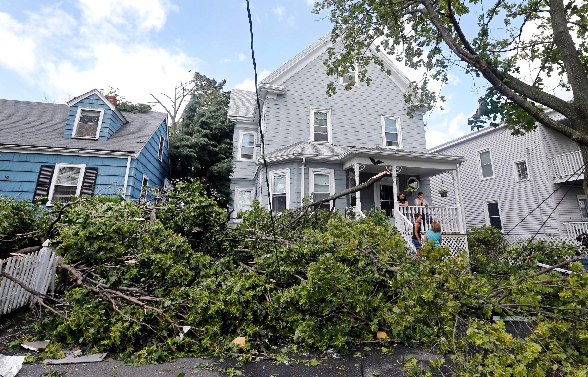 Downed trees and power lines lay in front of homes in Revere, Mass., on July 28, 2014 after a tornado touched down.