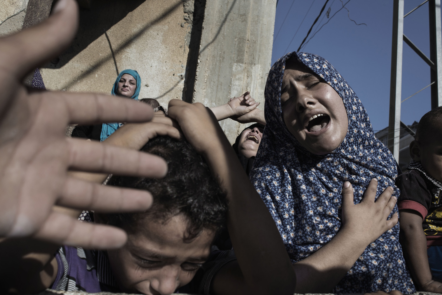 Relatives of four boys from the Bakr family, mourning at their funeral in Gaza City, July 16, 2014. (Alessio Romenzi)