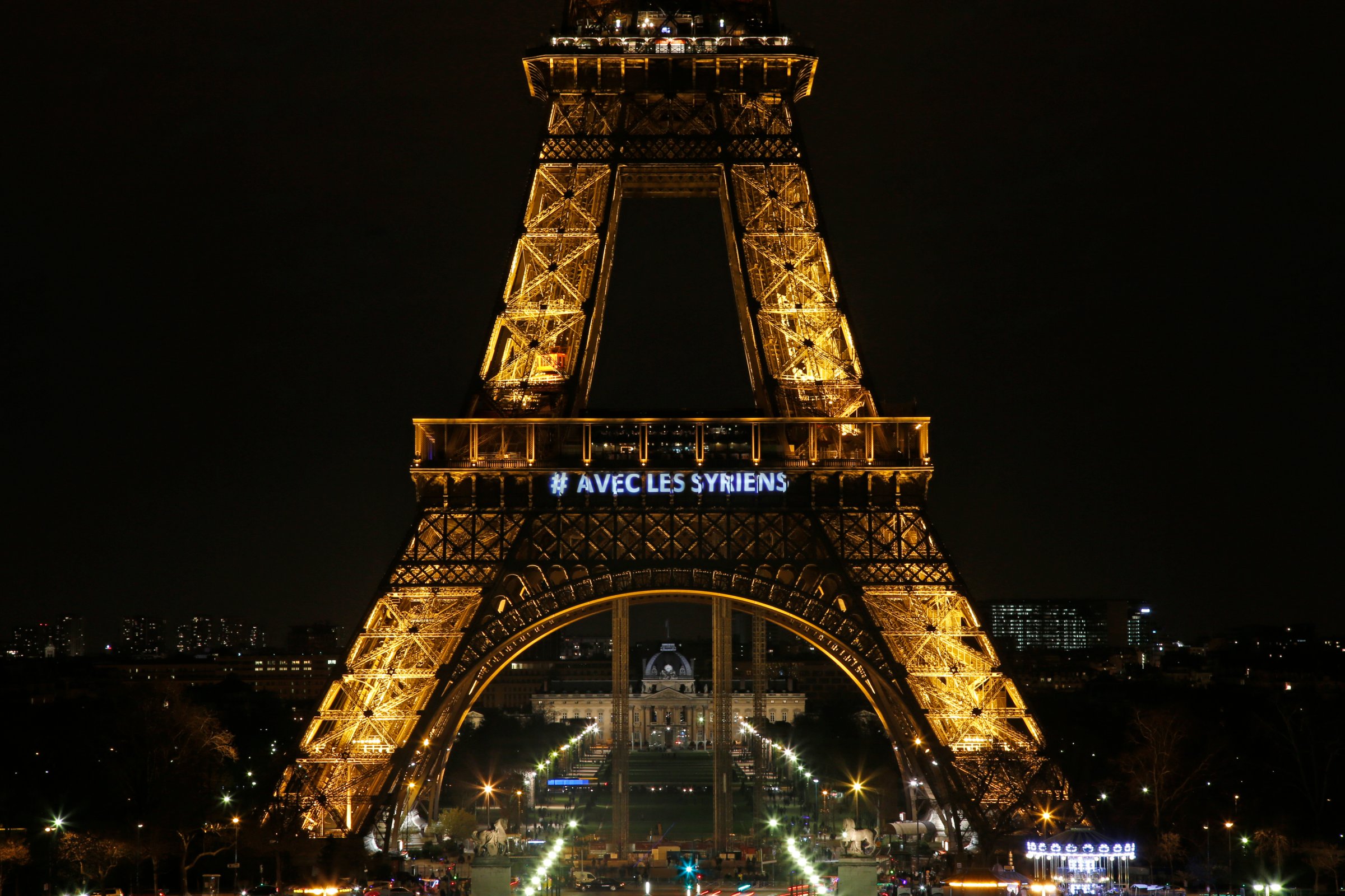 The words "With the Syrians" are displayed on the Eiffel Tower in support of Syrians on the third anniversary of the conflict, in Paris