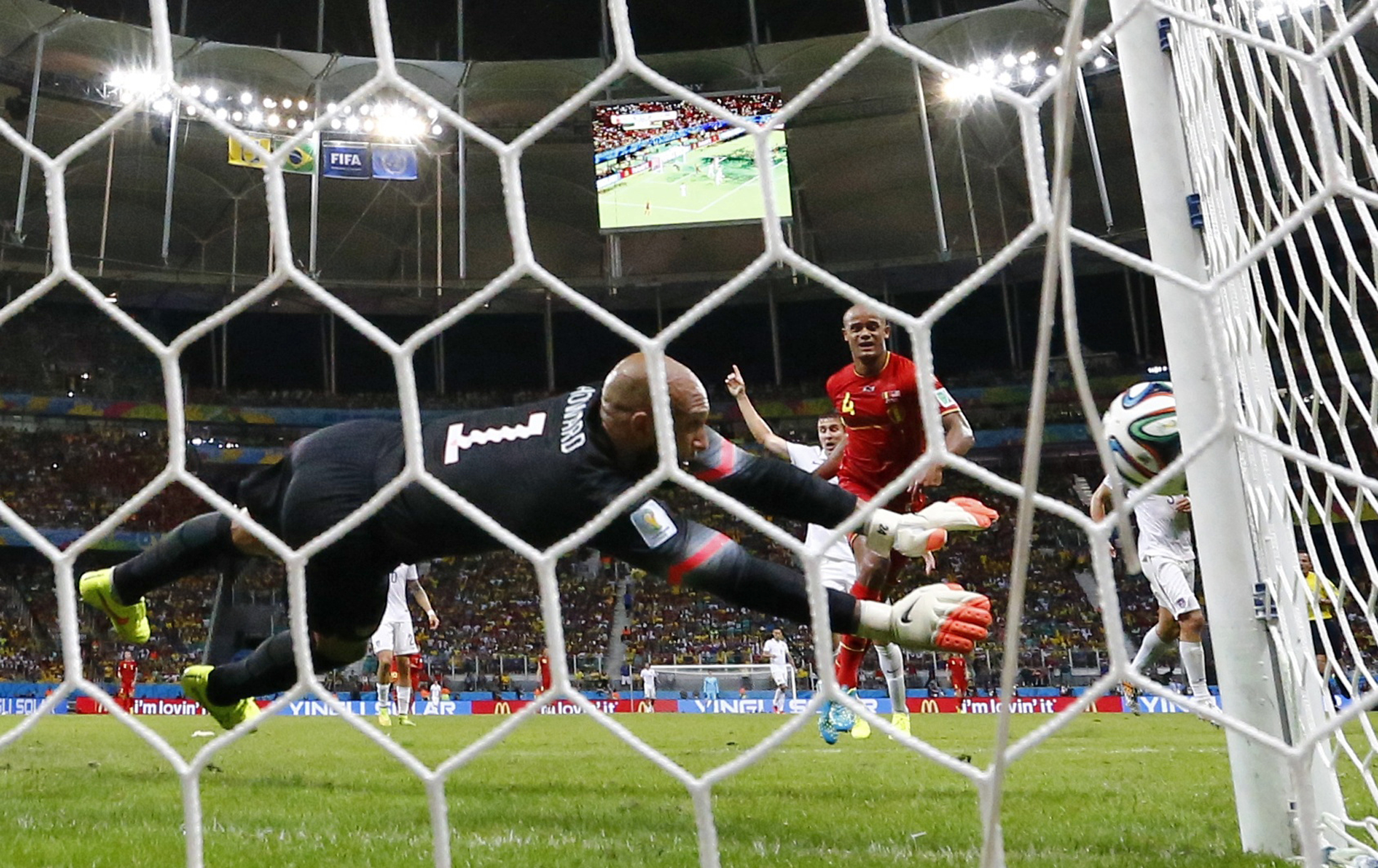 Goalkeeper Howard of the U.S. blocks a shot from Belgium's Kompany during their 2014 World Cup round of 16 game at the Fonte Nova arena in Salvador