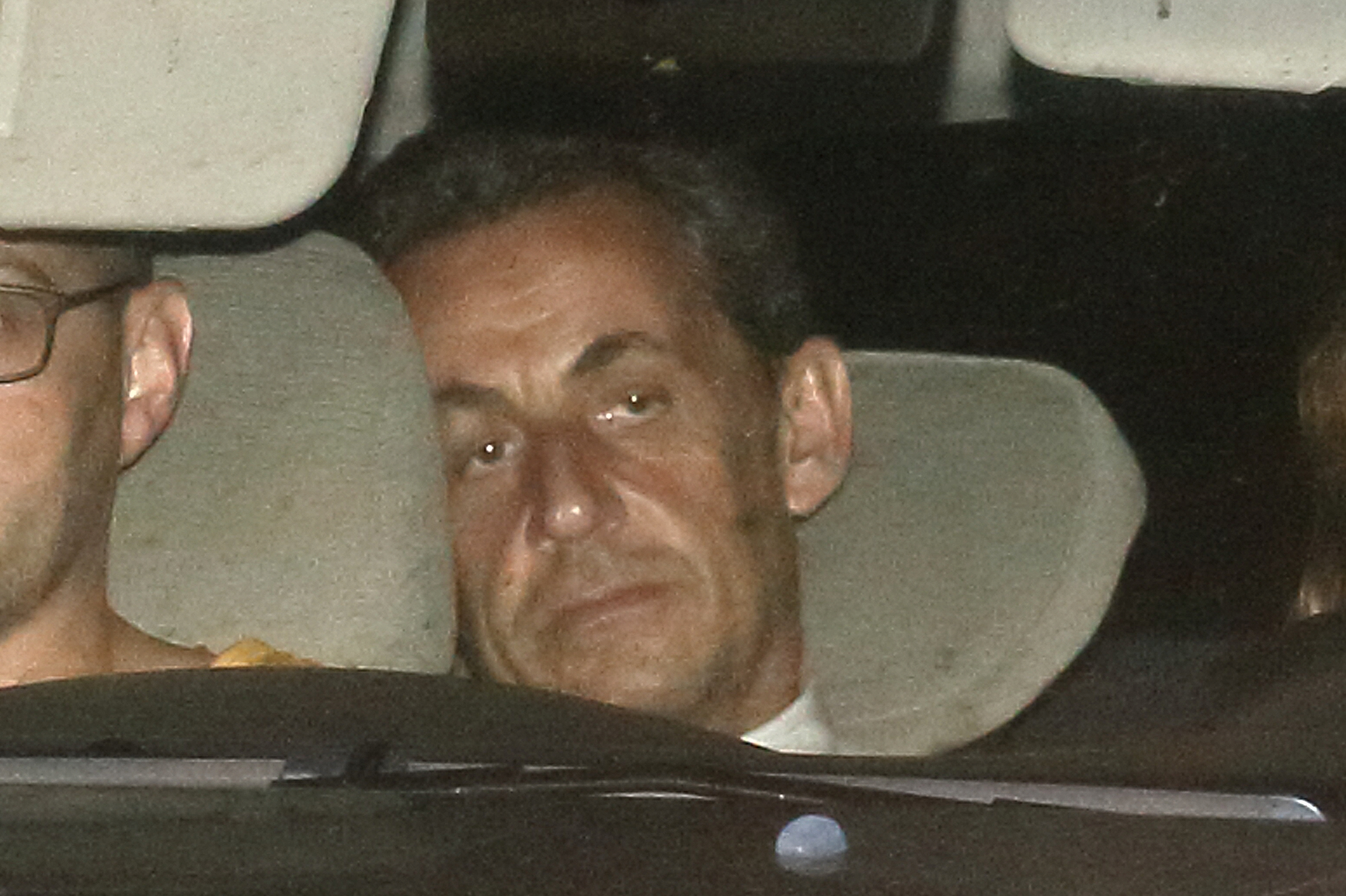 Former French President Nicolas Sarkozy arrives with police by car at the financial investigation unit in Paris to be presented to a judge late July 1, 2014. Former French President Sarkozy was held for questioning for 15 hours on Tuesday over suspicions he used his influence to secure leaked details of an inquiry into alleged irregularities in his 2007 election campaign. (Pascal Rossignol—Reuters)