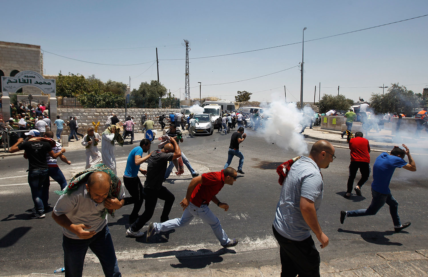 Palestinian protesters run away from tear gas in Ras al-Amud