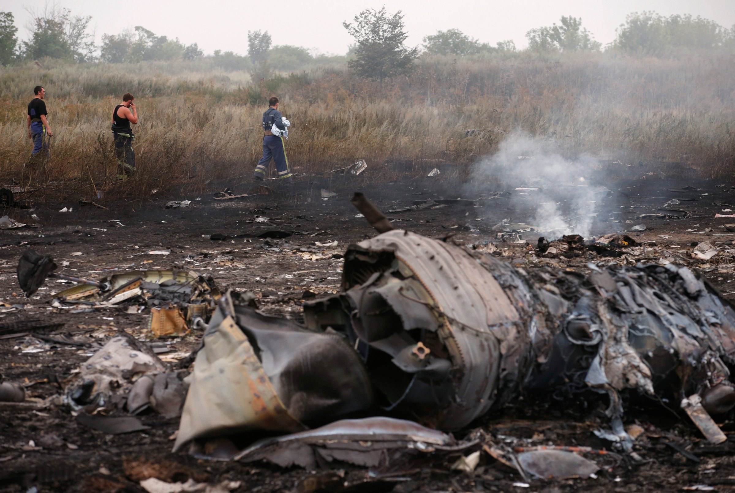 Emergencies Ministry members walk at the site of a Malaysia Airlines Boeing 777 plane crash, MH17, near the settlement of Grabovo in the Donetsk region