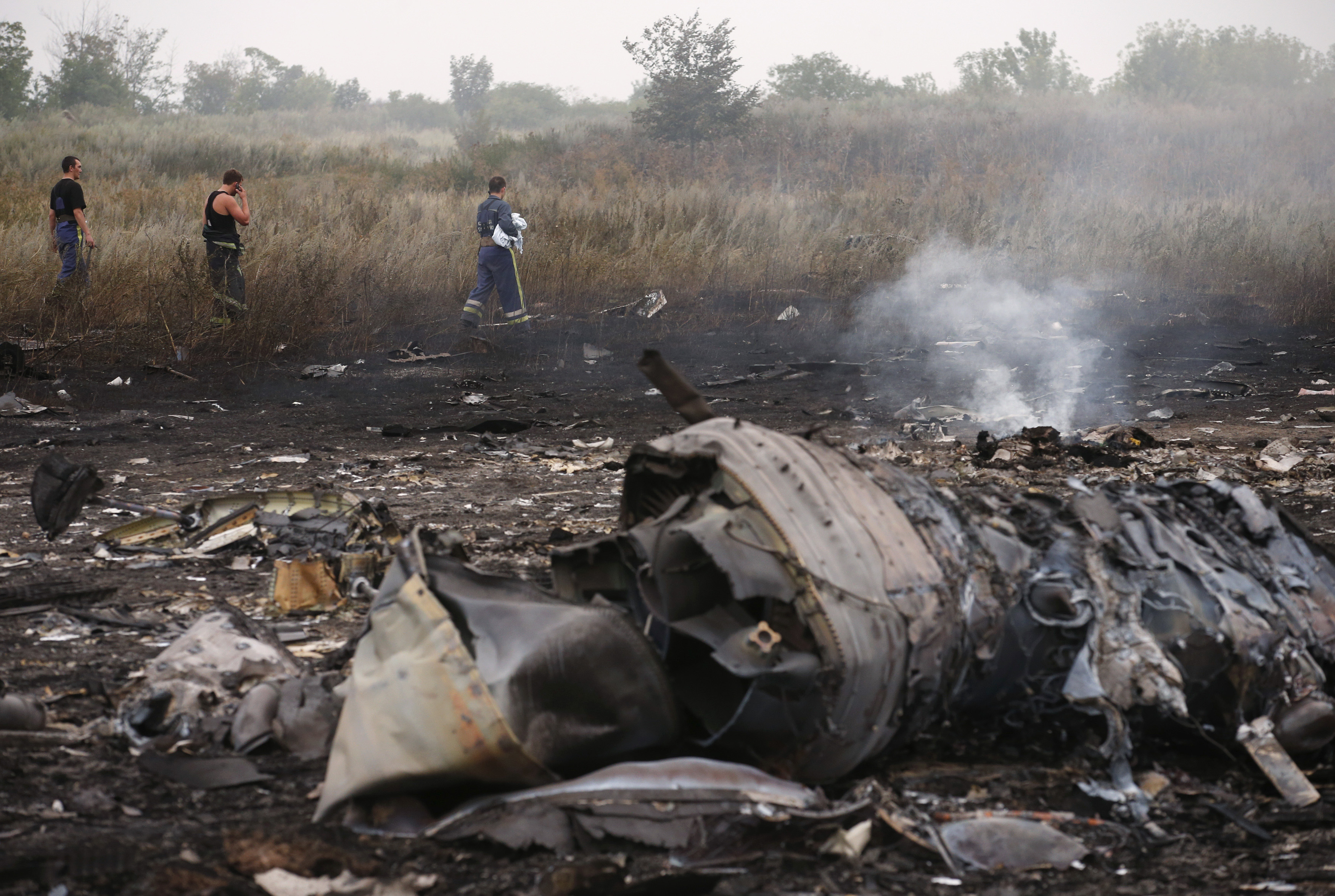 Emergencies Ministry members walk at the site of a Malaysia Airlines Boeing 777 plane crash, MH17, near the settlement of Grabovo in the Donetsk region, on July 17, 2014. (Maxim Zmeyev&mdash;Reuters)