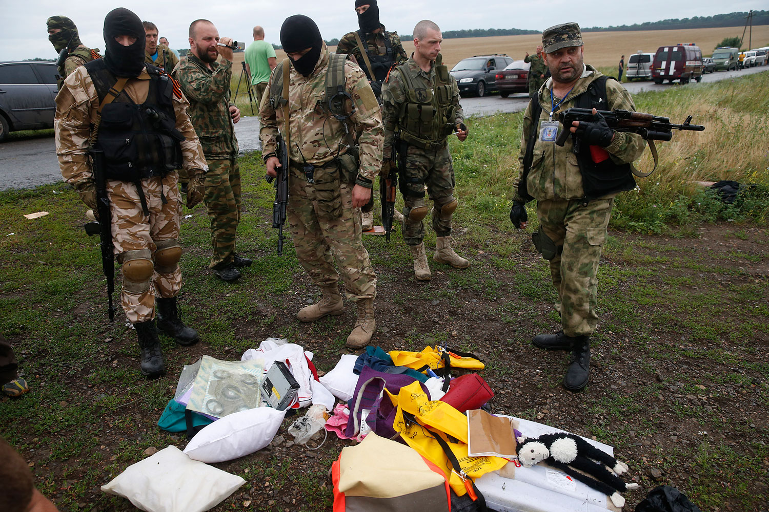 Pro-Russian separatists look at passengers' belongings at the crash site of Malaysia Airlines flight MH17, near the settlement of Grabovo in the Donetsk region