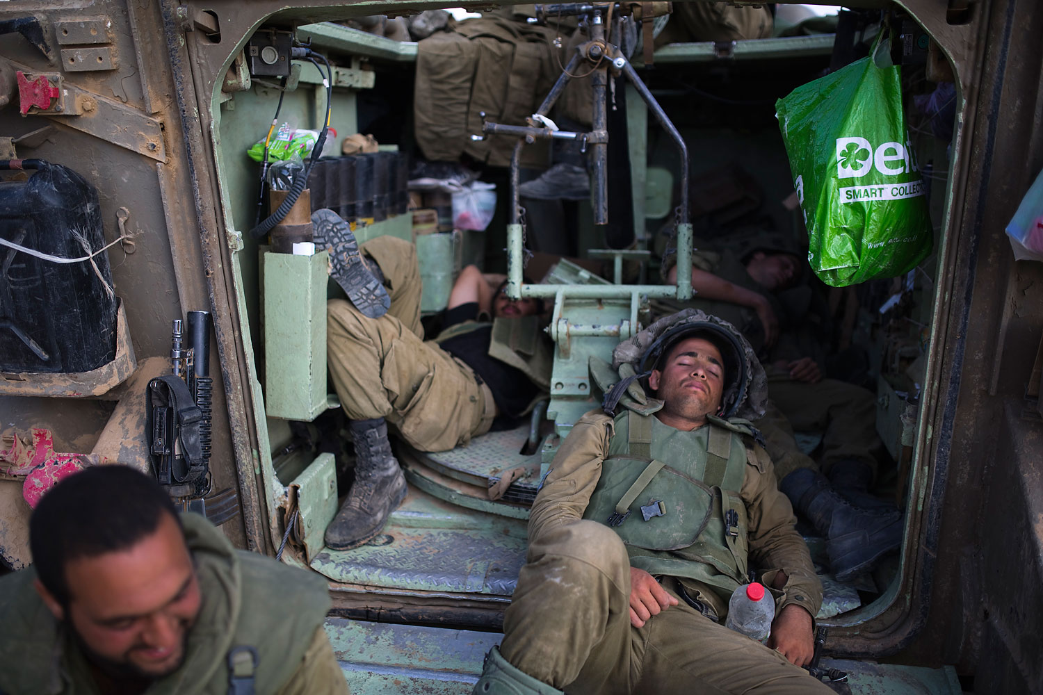 Israeli soldiers rest inside an armoured personnel carrier outside central Gaza Strip