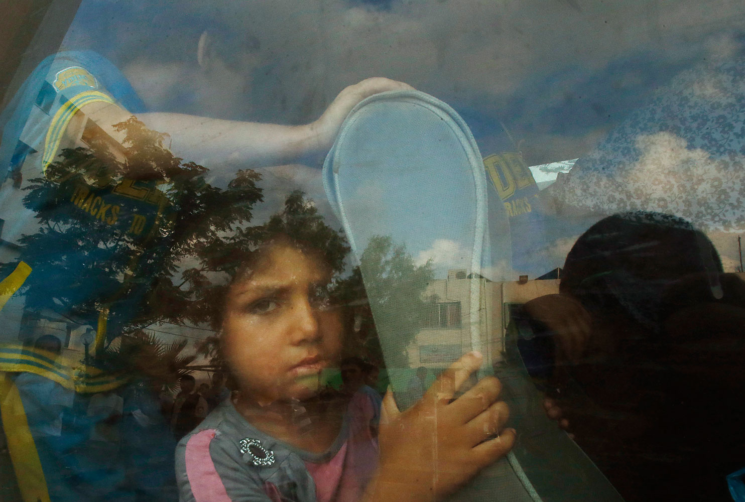 A Palestinian girl sits in a minibus after fleeing her family's house during heavy Israeli shelling, in Gaza City
