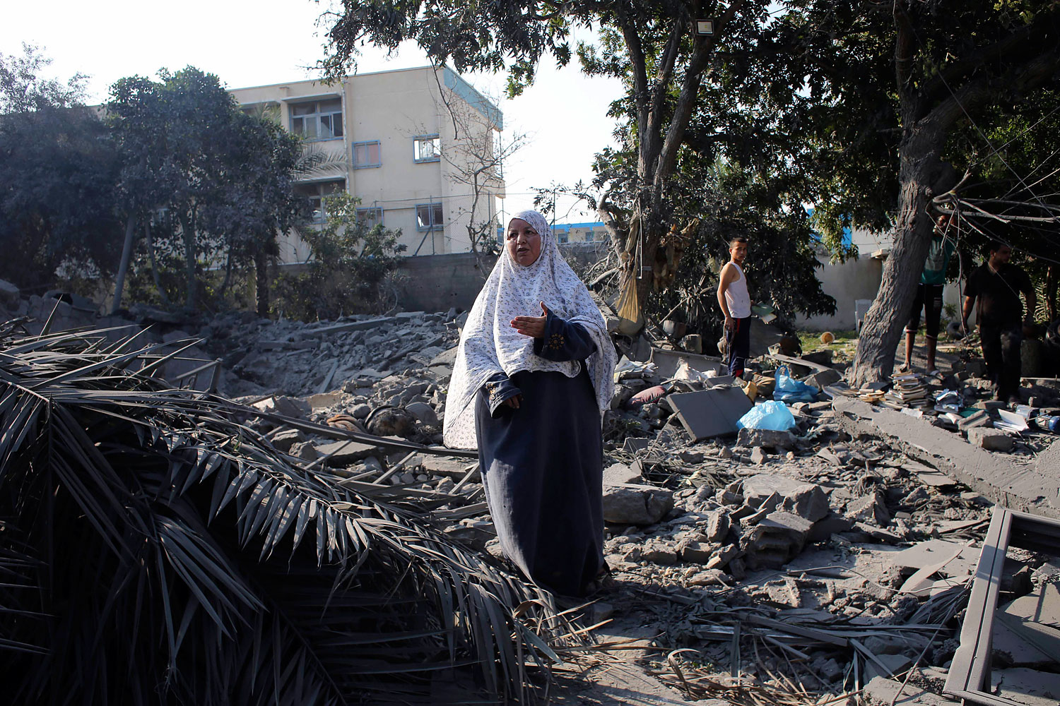 Palestinian woman gestures as she stands amidst the rubble of her house which police said was destroyed in an Israeli air strike in Rafah in the southern Gaza Strip
