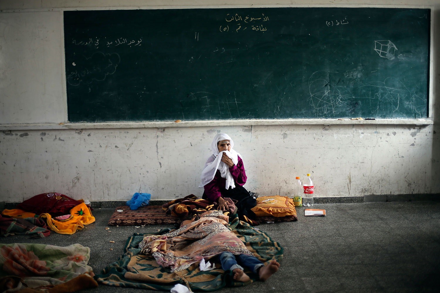 Palestinian woman, who fled her house following an Israeli ground offensive, stays at a United Nations-run school in Rafah in the southern Gaza Strip