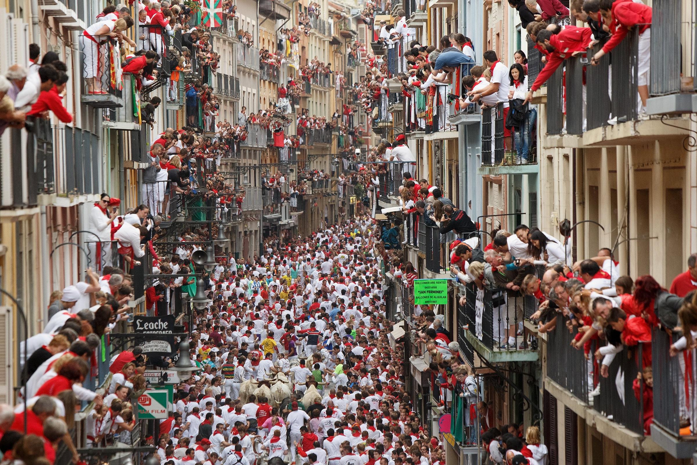 Revellers run with Torrestrella's fighting bulls along the Calle Estafeta during the second day of the San Fermin Running Of The Bulls festival on July 7, 2014 in Pamplona, Spain.