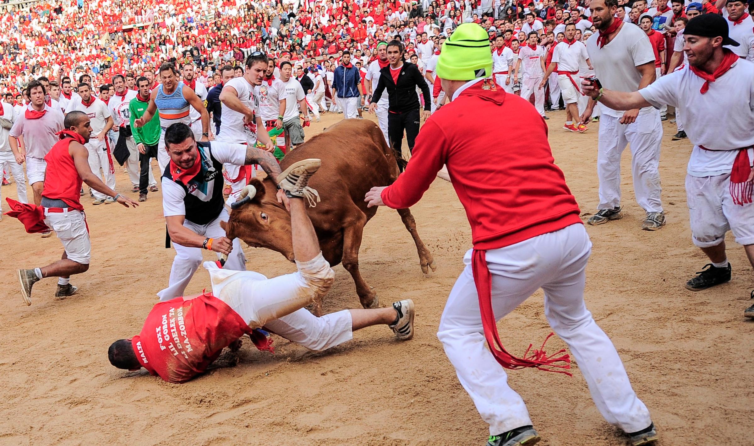 A reveler is hit by a cow on the bull ring, at the San Fermin festival, in Pamplona, Spain on July 8, 2014.