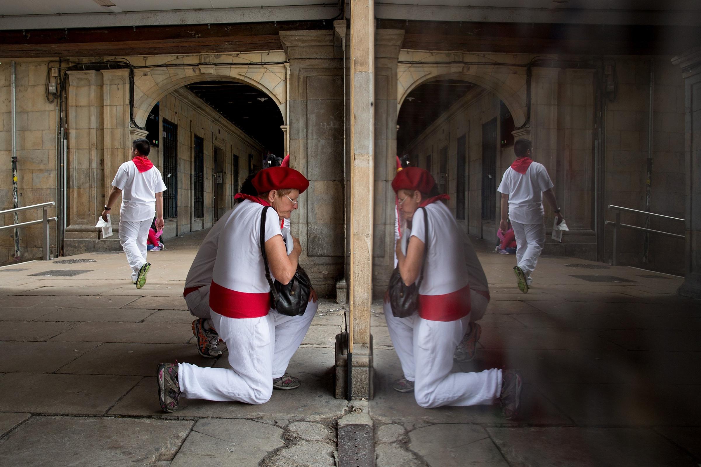 A reveller checks pictures of runners at a photo shop after the Dolores Aguirre Ybarra's fighting bulls during the third day of the San Fermin Running Of The Bulls festival on July 8, 2014 in Pamplona, Spain.