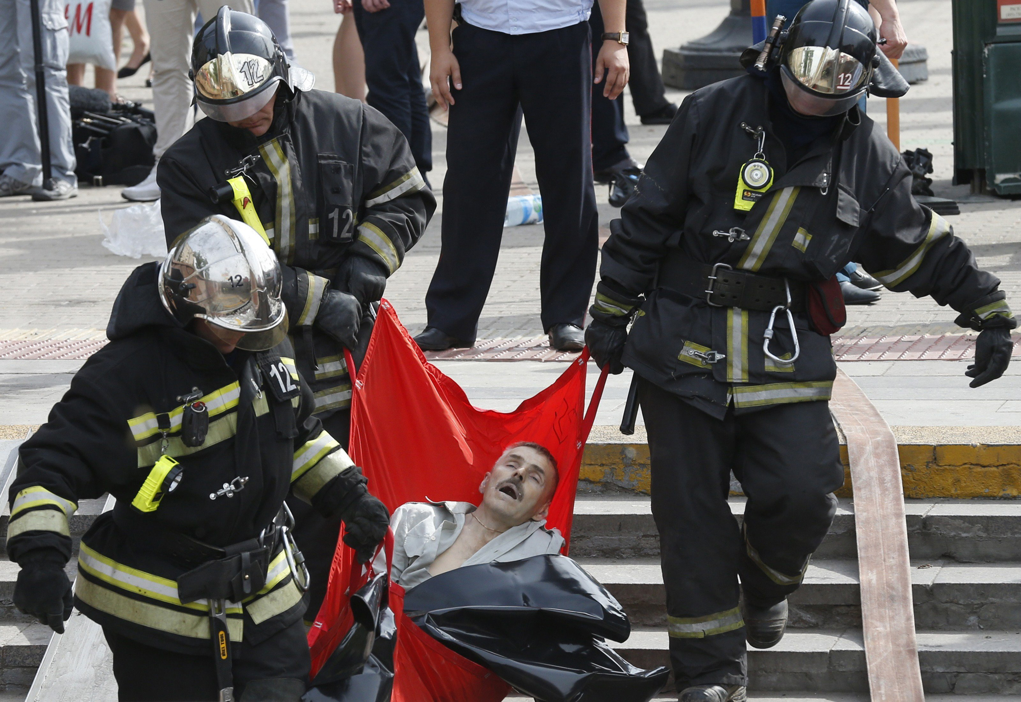 Rescuers carry a passenger injured as several subway cars derailed in Moscow, on July 15, 2014.