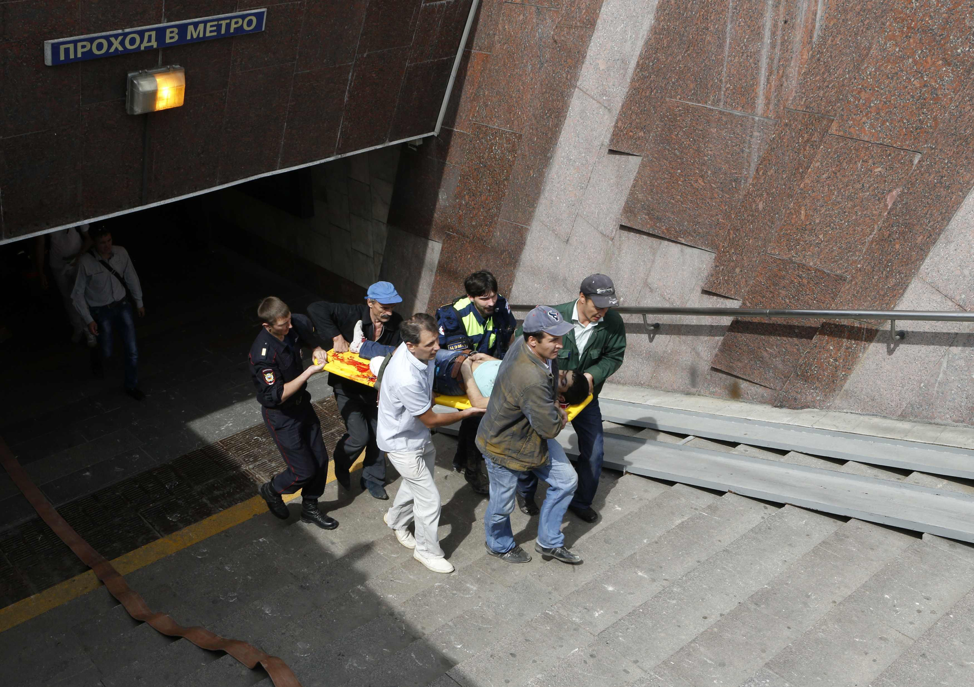 Members of the emergency services carry an injured passenger outside a metro station following an accident on the subway in Moscow July 15, 2014.