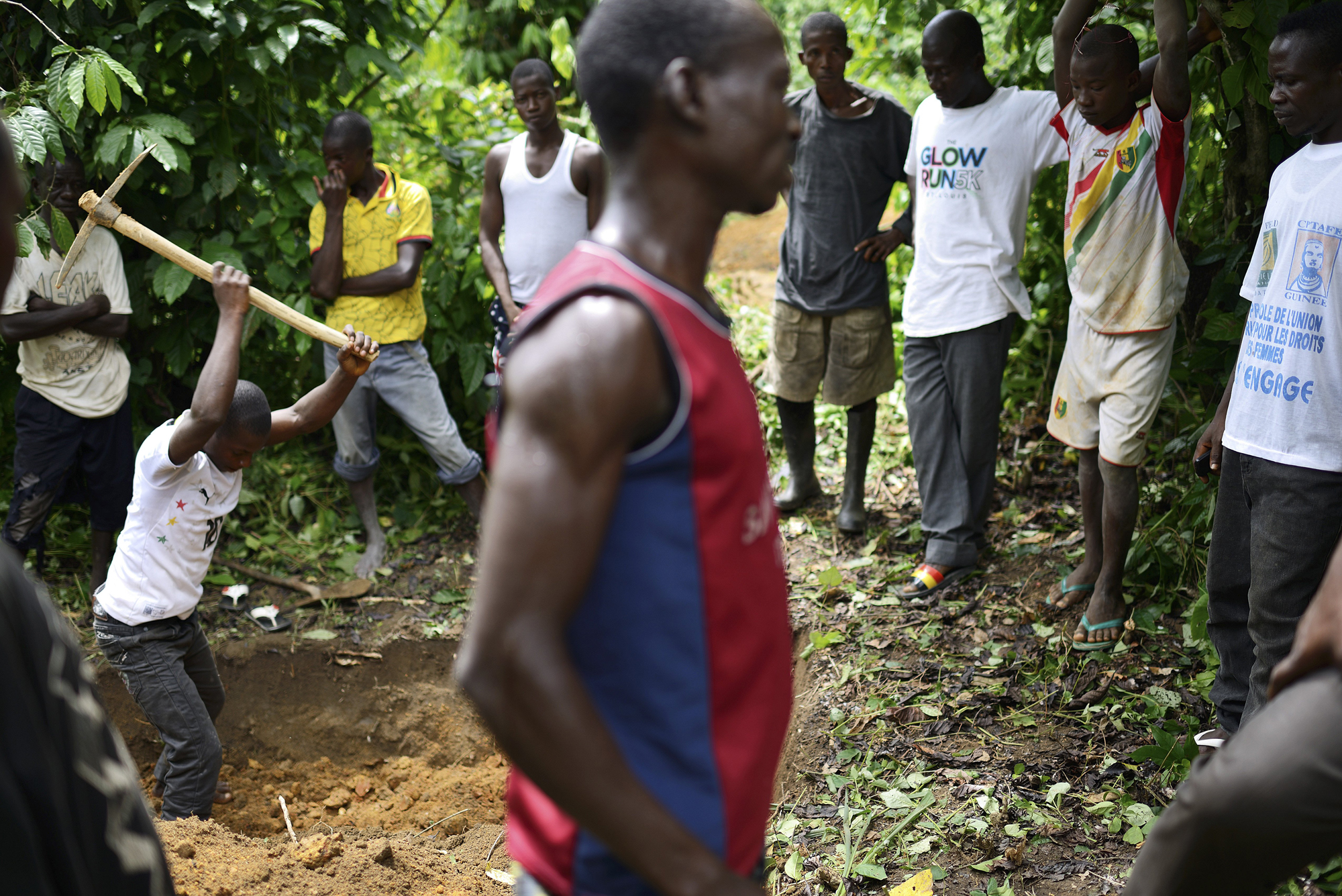 A man digs a grave in the bush where other 26 victims of the Ebola virus have been buried in Koundony, Guinea.