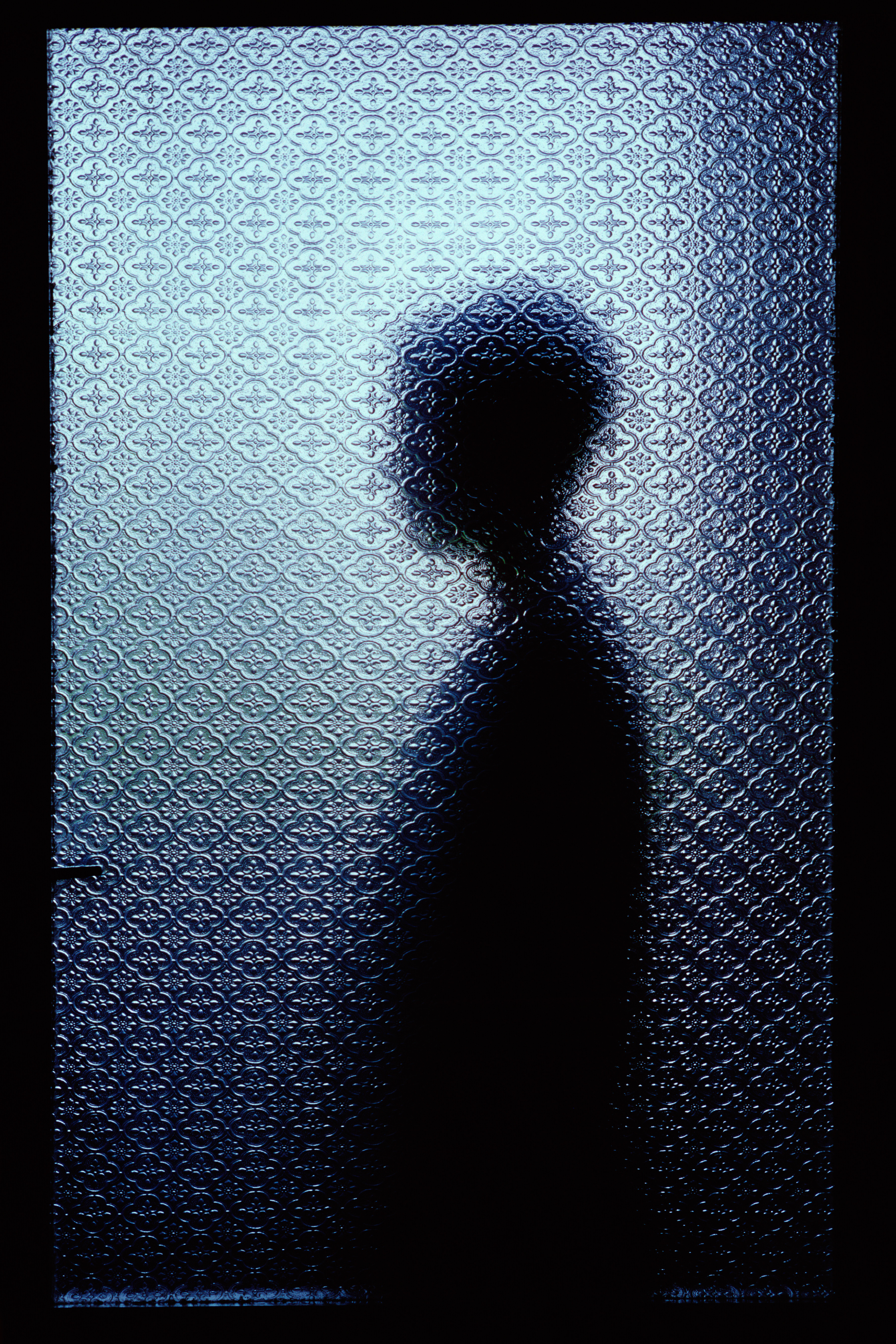 Silhouetted man through window