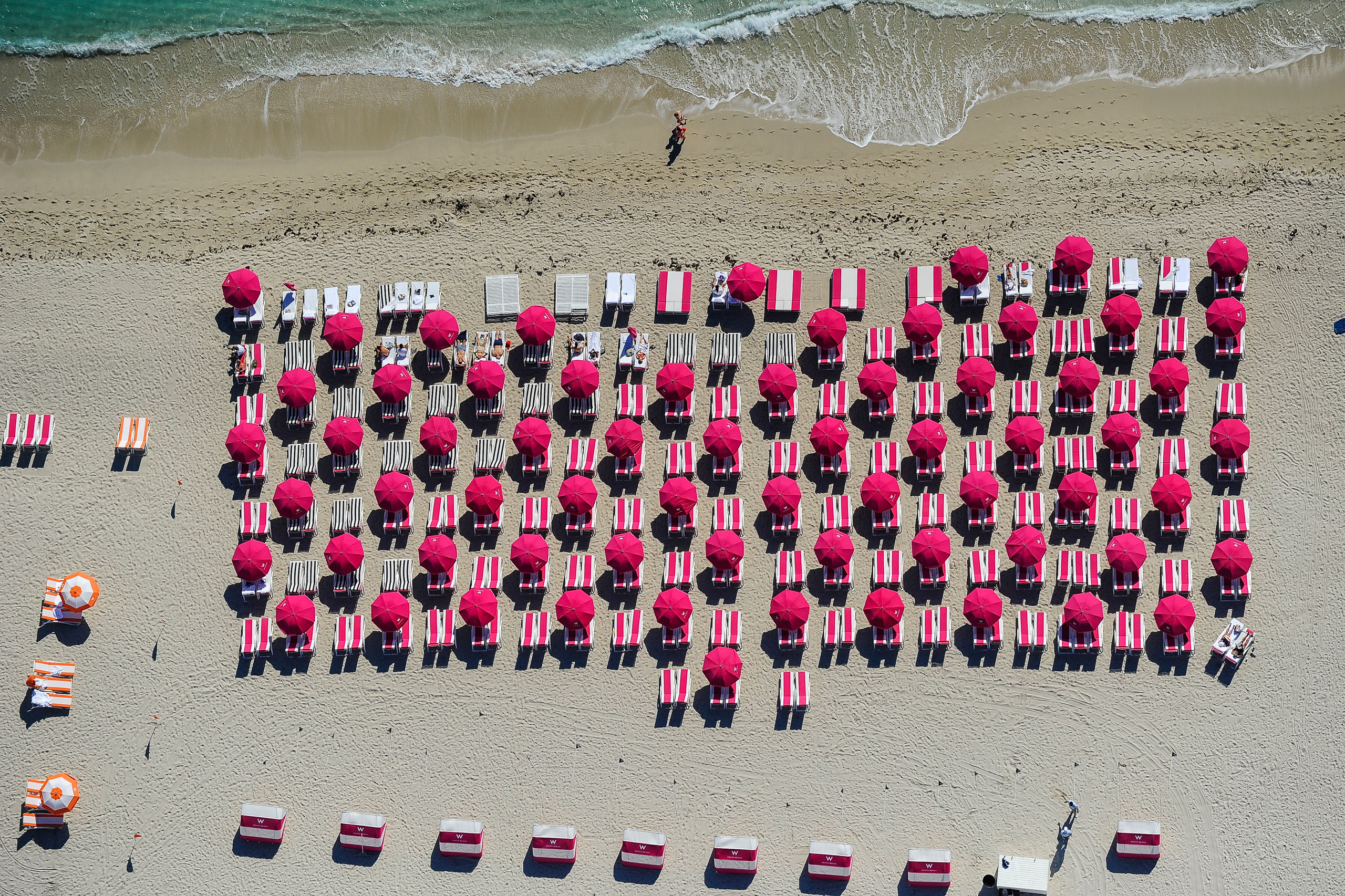 Sunbathers lounge on pink beach chairs outside the W South Beach hotel on March 8, 2014 in Doral, Florida.