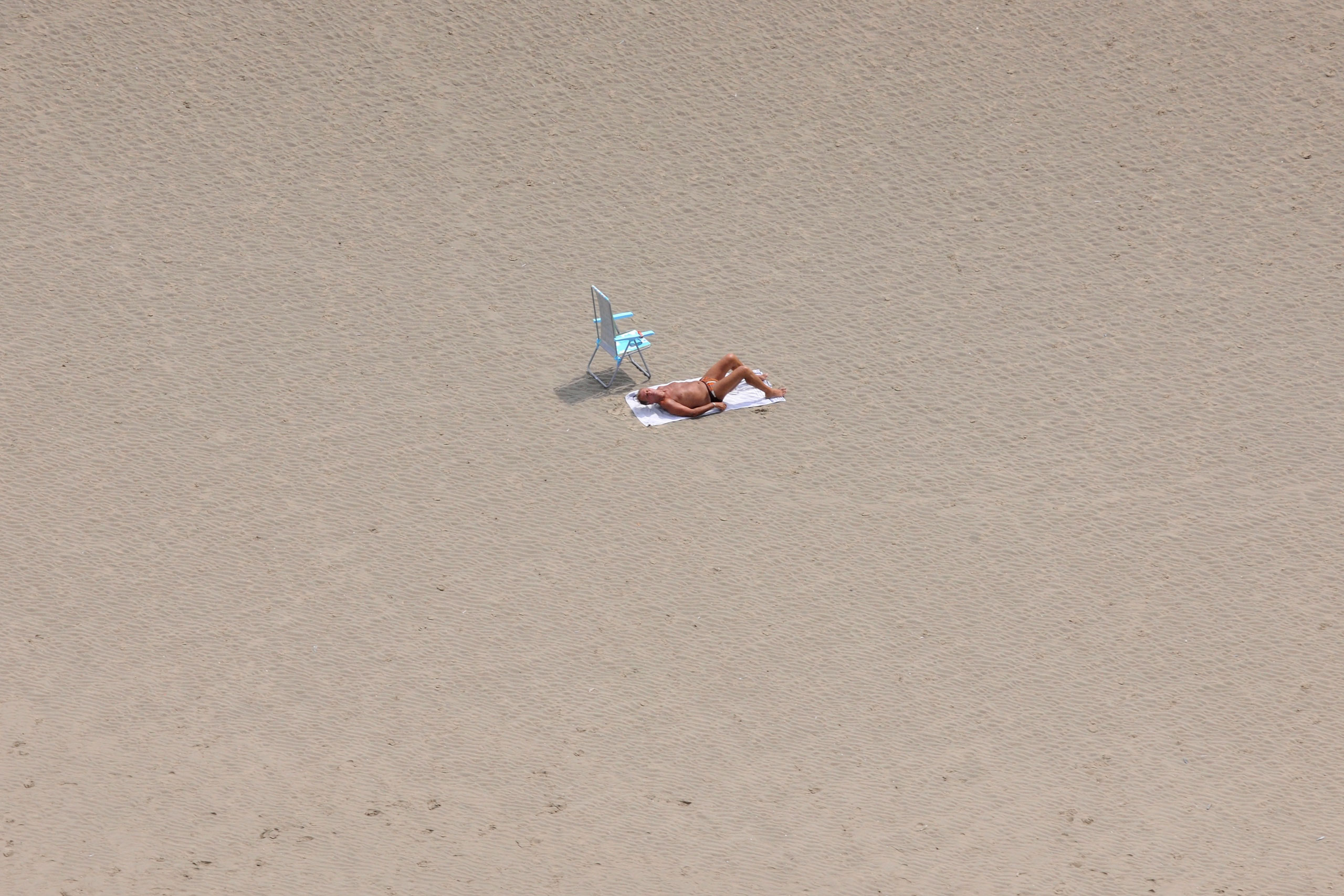 An aerial view of a lone sunbather on De Panne beach on July 17, 2013 in Belgium.