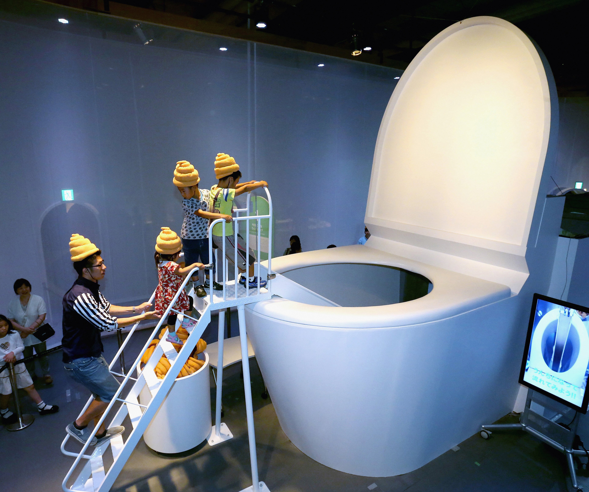 Children play at the 5-meter-tall toilet shaped slider during the 'Toilet!? Human Waste and Earth's Future' exhibition at The National Museum of Emerging Science and Innovation - Miraikan on July 5, 2014 in Tokyo.