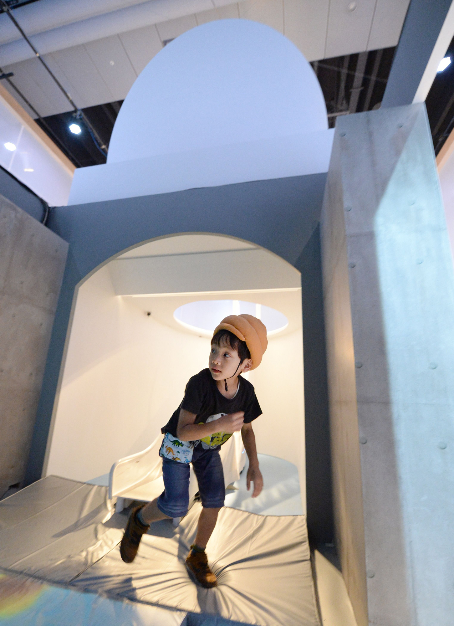 A child wearing a poo-shaped hat gets up from a giant toilet slide at a toilet exhibition at the National Museum of Emerging Science and Innovation in Tokyo on July 9, 2014.