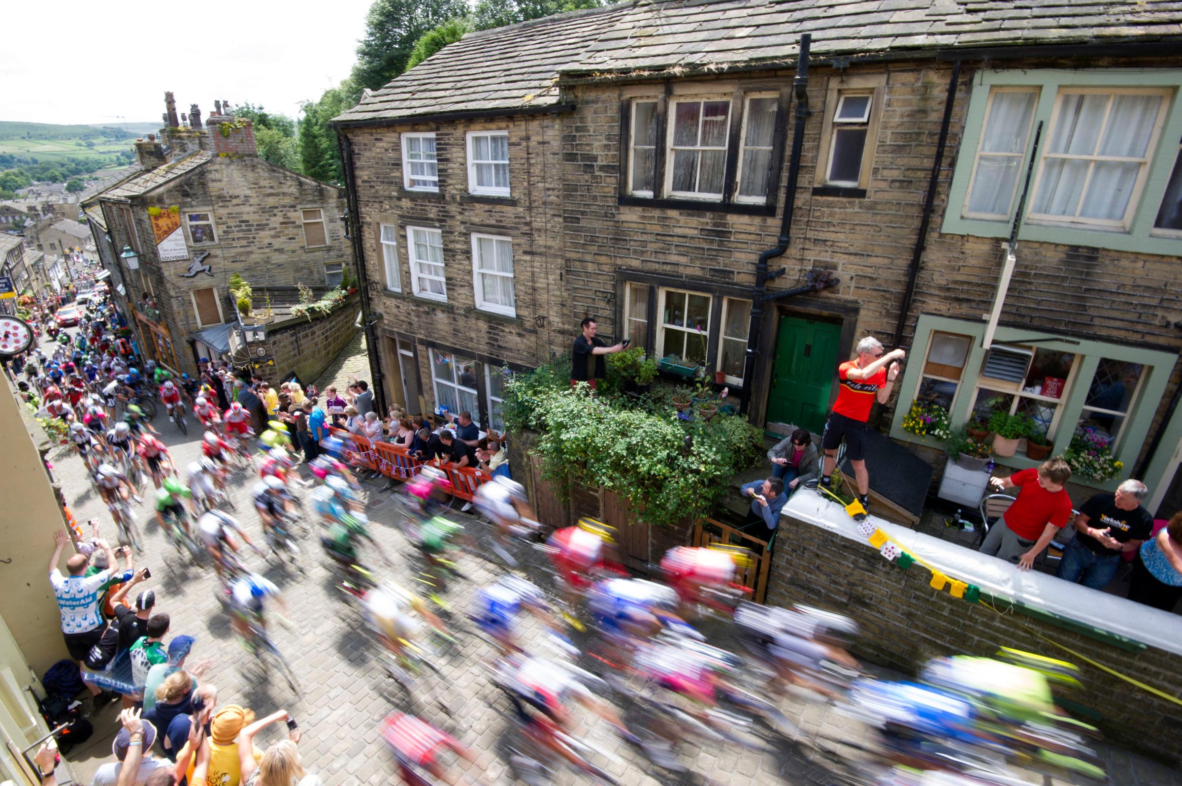 The peloton rides up Main Street as stage two of the Tour de France passes through Haworth, Yorkshire on July 6, 2014.