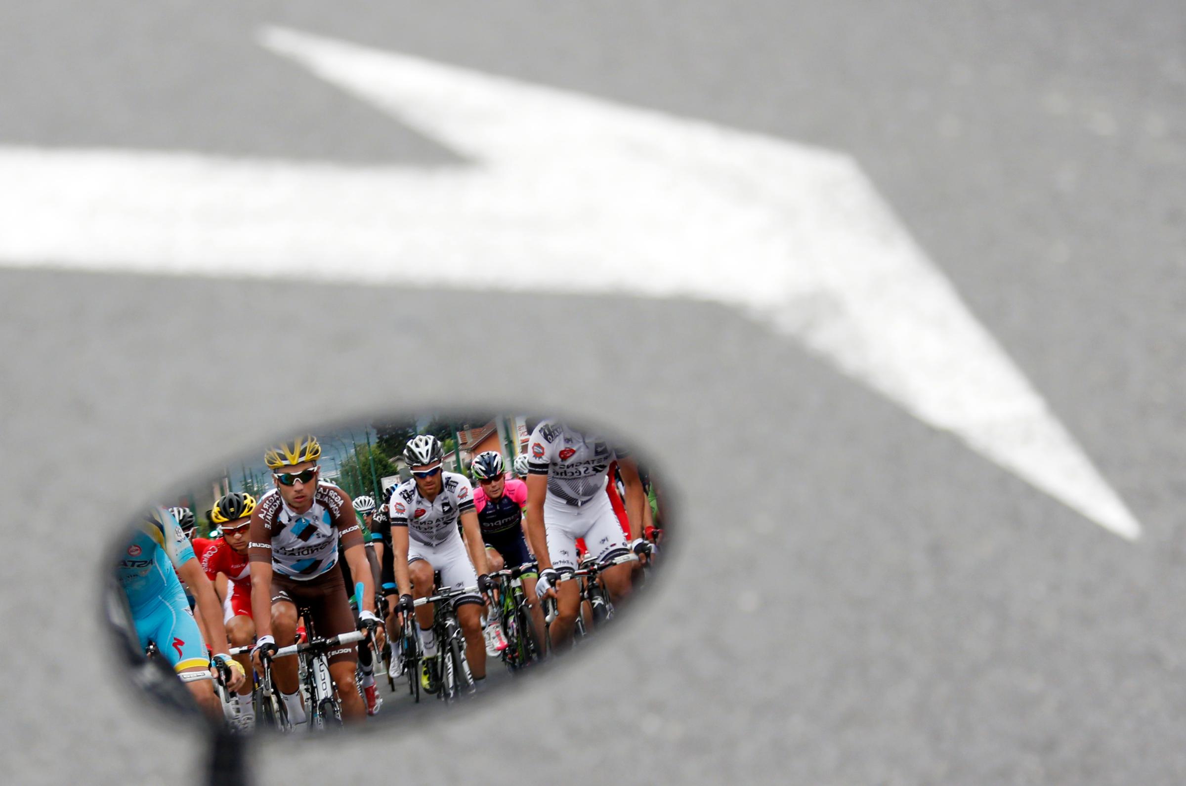 The pack of riders is reflected in a rear mirror during the 177-km fourteenth stage of the Tour de France cycling race