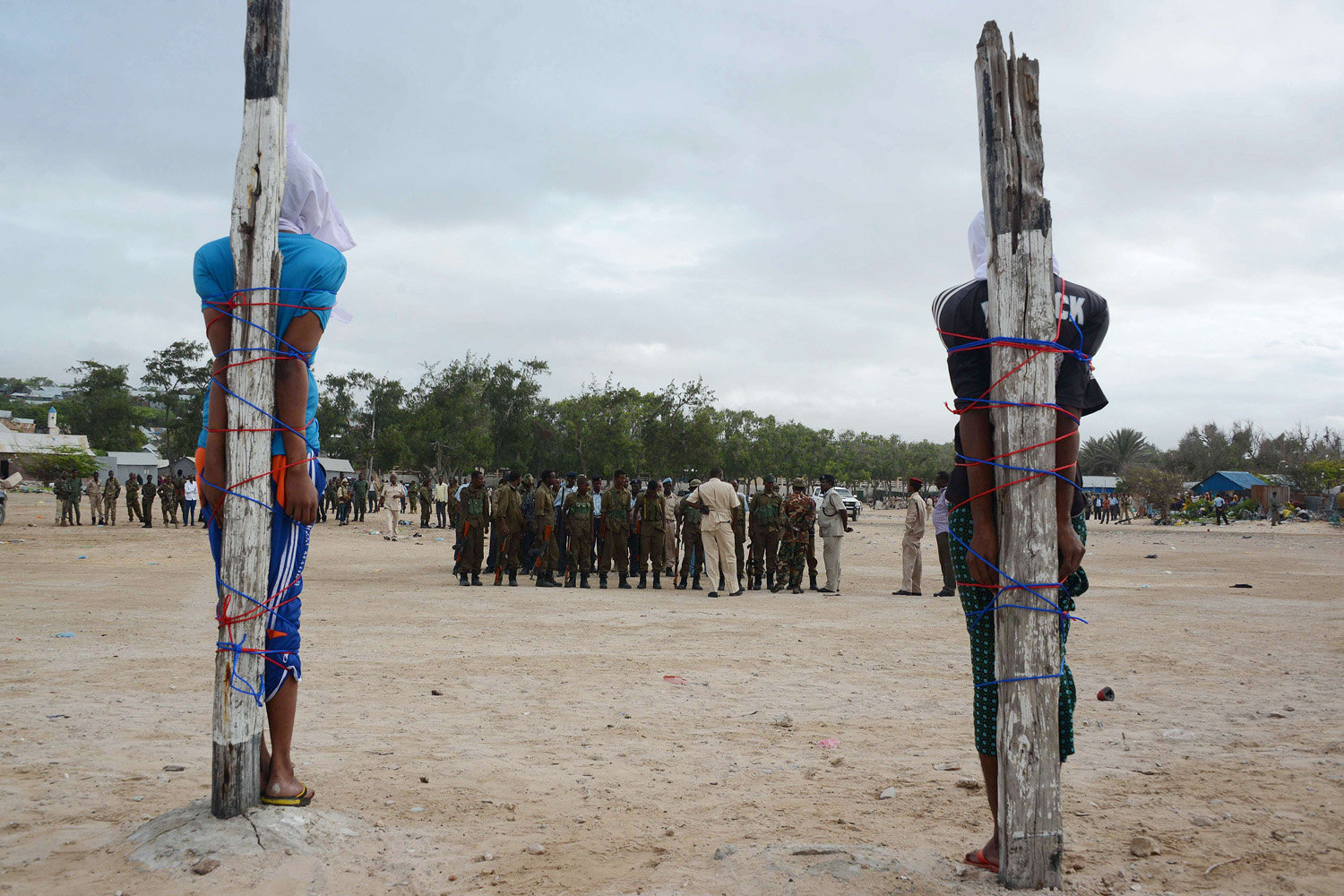 Two Somalis, convicted of the murder of a Somali nurse are tied to wooden stakes as they wait to be executed by a firing squad in Mogadishu, Somalia on July 15, 2014.