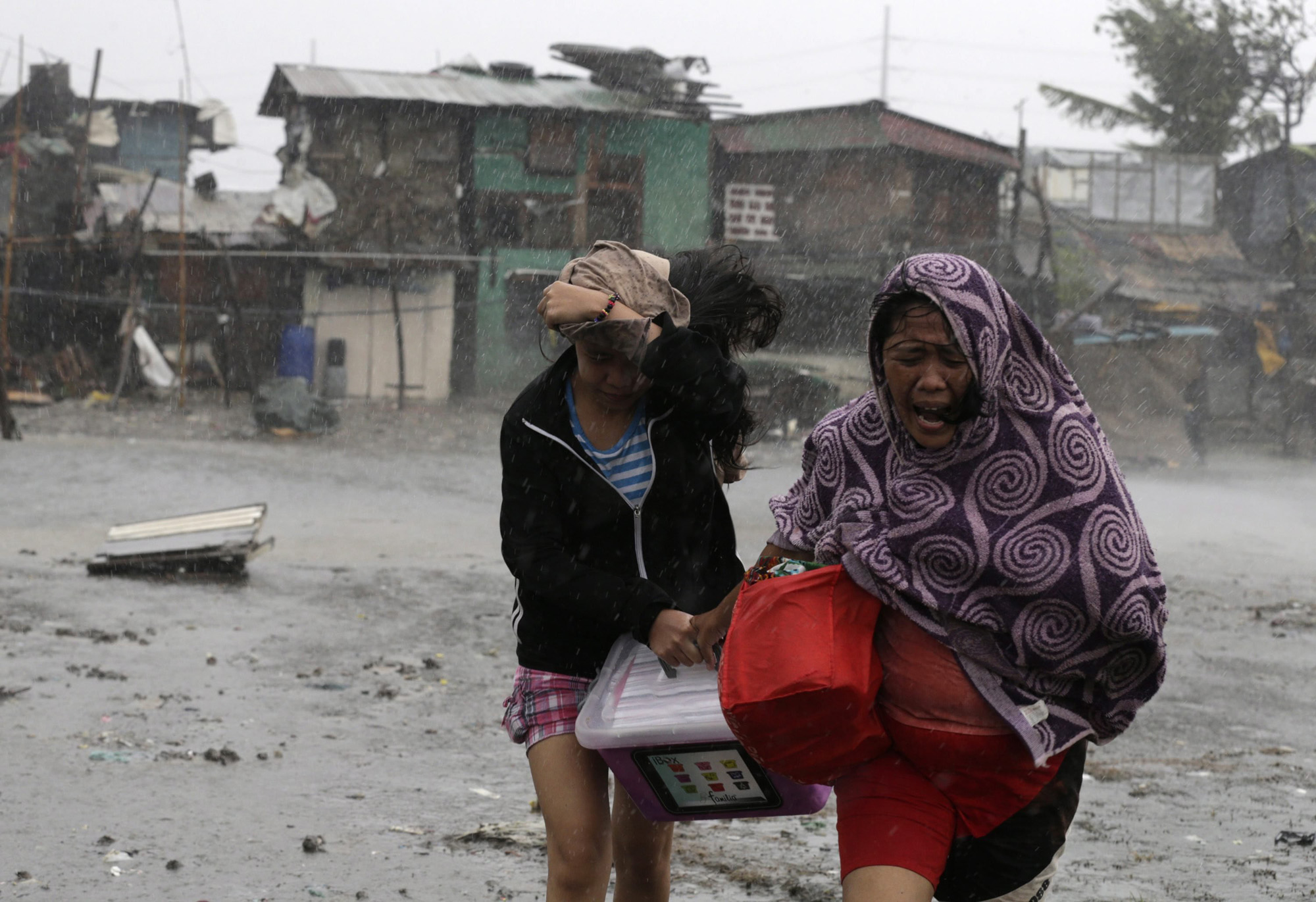 Residents flee strong winds and rain brought by typhoon Typhoon Rammasun in Las Pinas city, south of Manila, July 16, 2014.