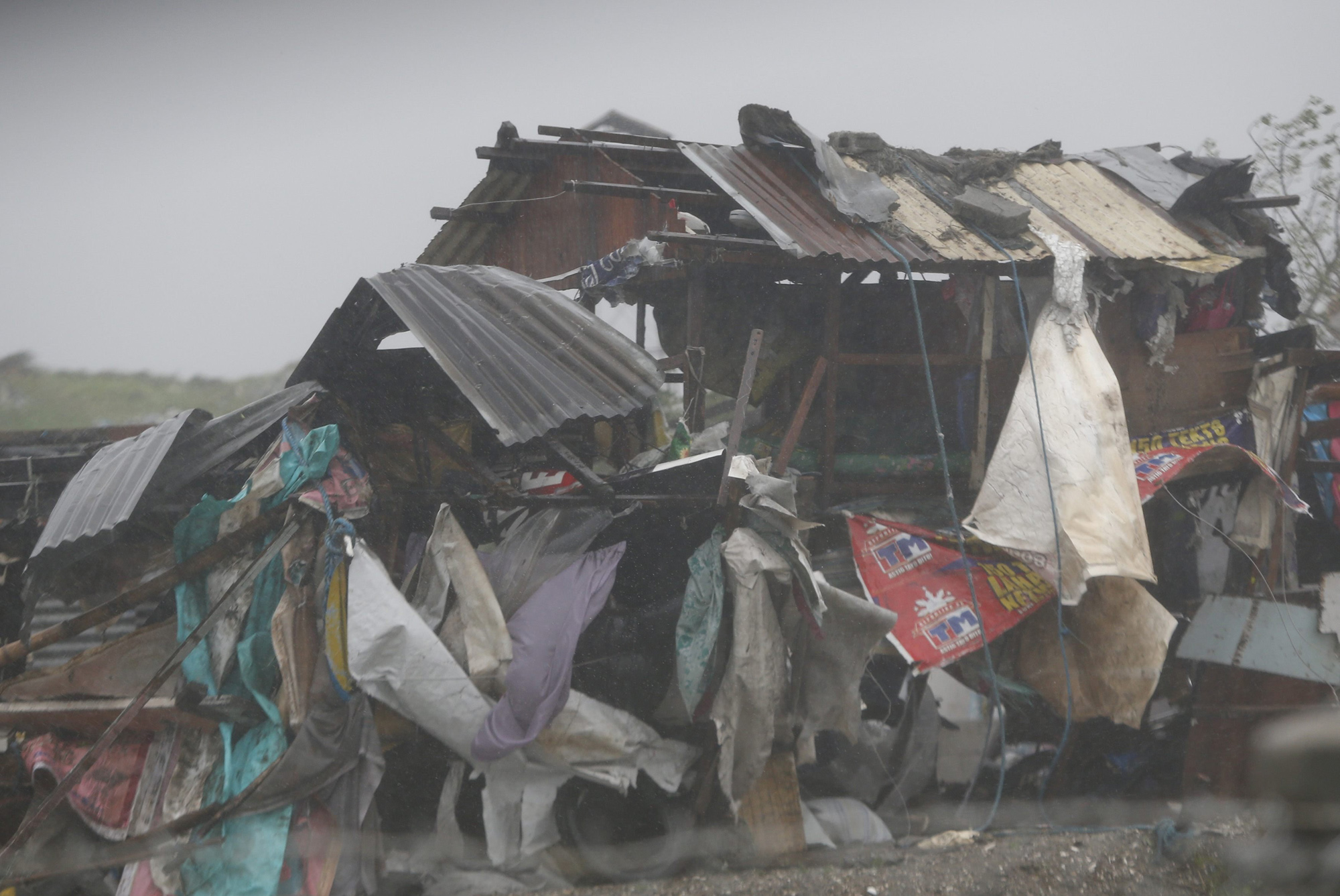A squatter's house is pounded by strong winds and rain brought by Typhoon Rammasun as it hit the coastal town of Bacoor, Cavite southwest of Manila, July 16, 2014.
