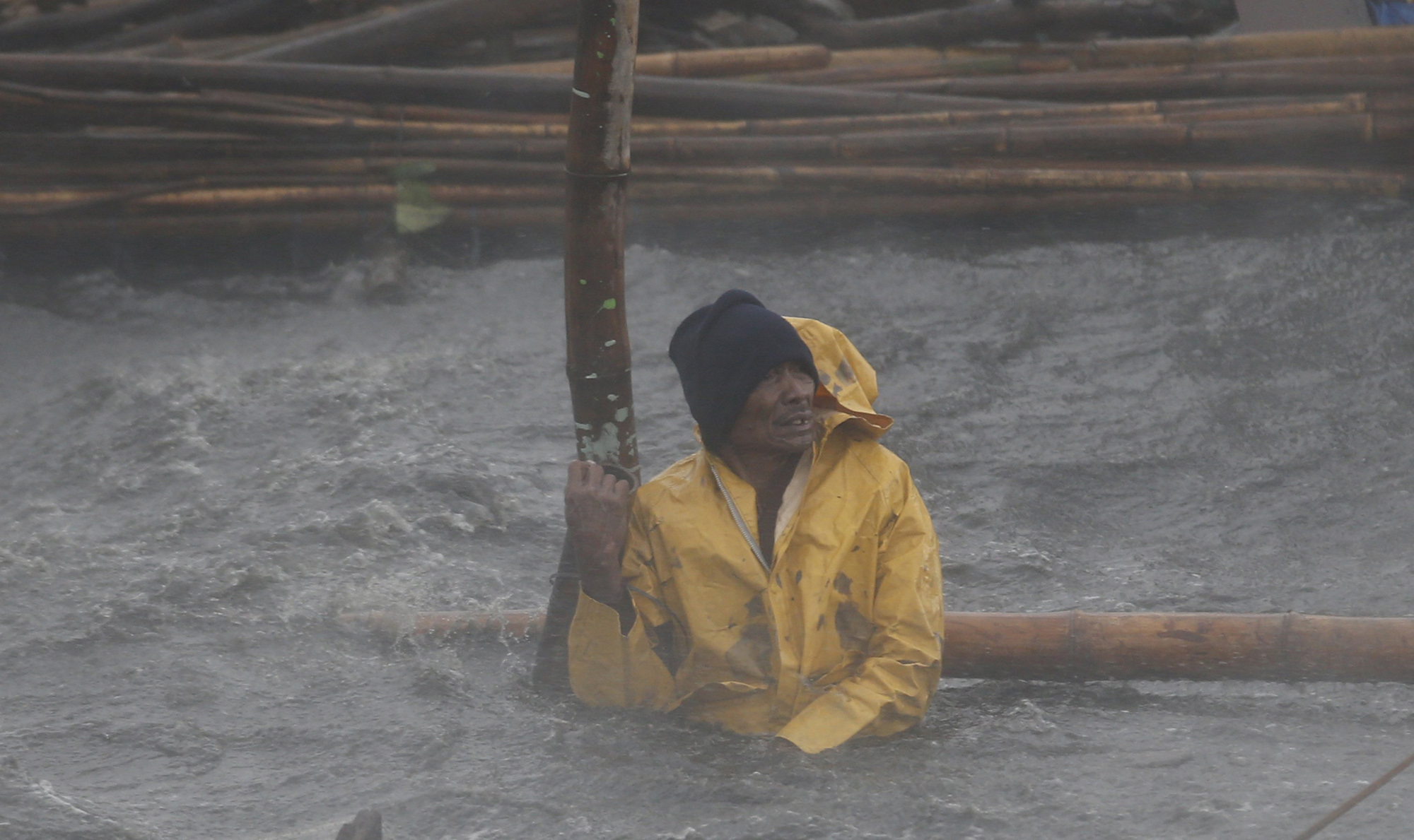 A fisherman secures his fishpen from strong winds and rain brought by Typhoon Rammasun as it hit the coastal town of Bacoor, Cavite southwest of Manila, July 16, 2014.