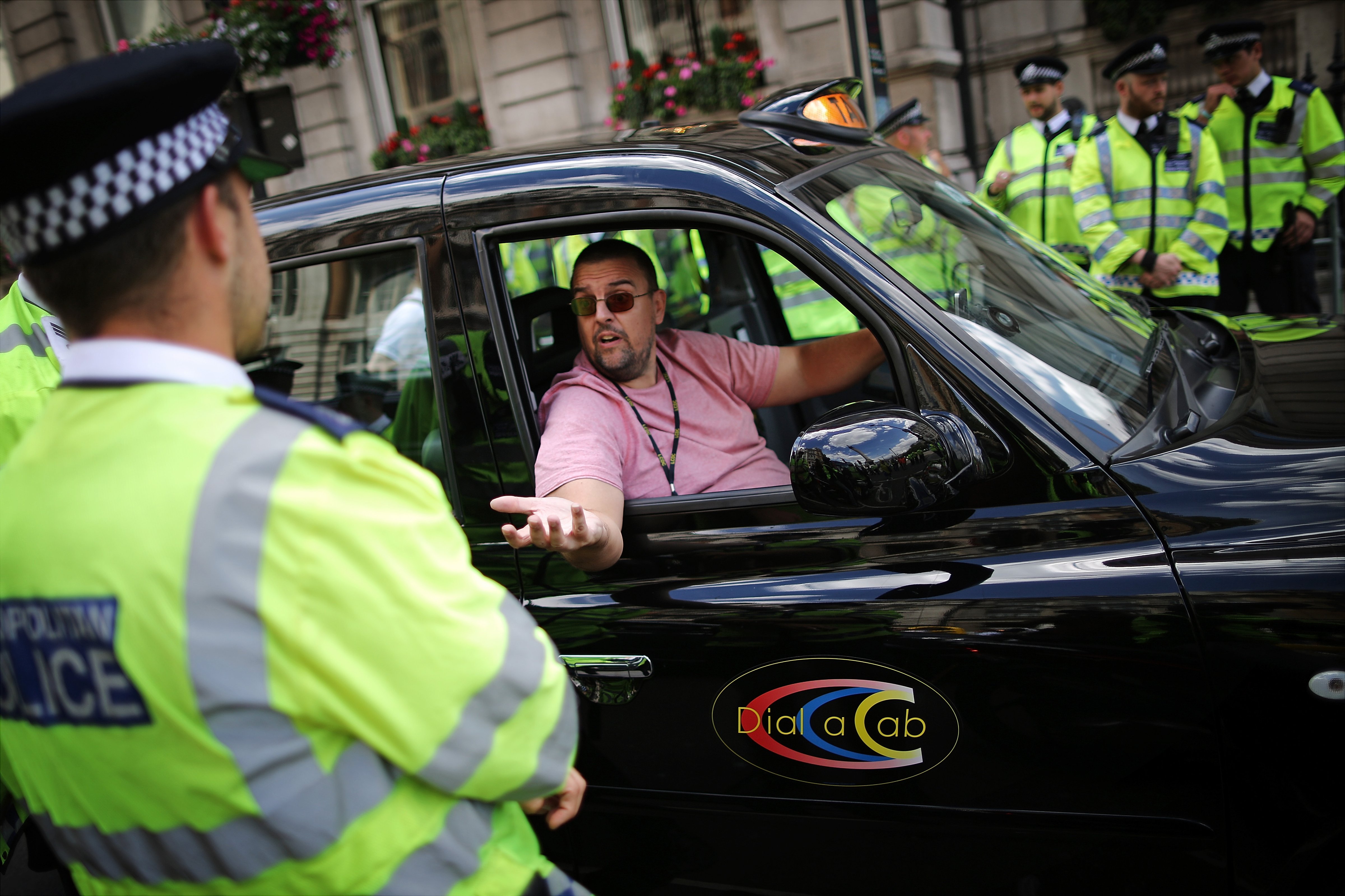 A London taxi driver speaks with Police Officers during a protest against a new smart phone app, 'Uber' on June 11, 2014 in London, England. (Dan Kitwood—Getty Images)