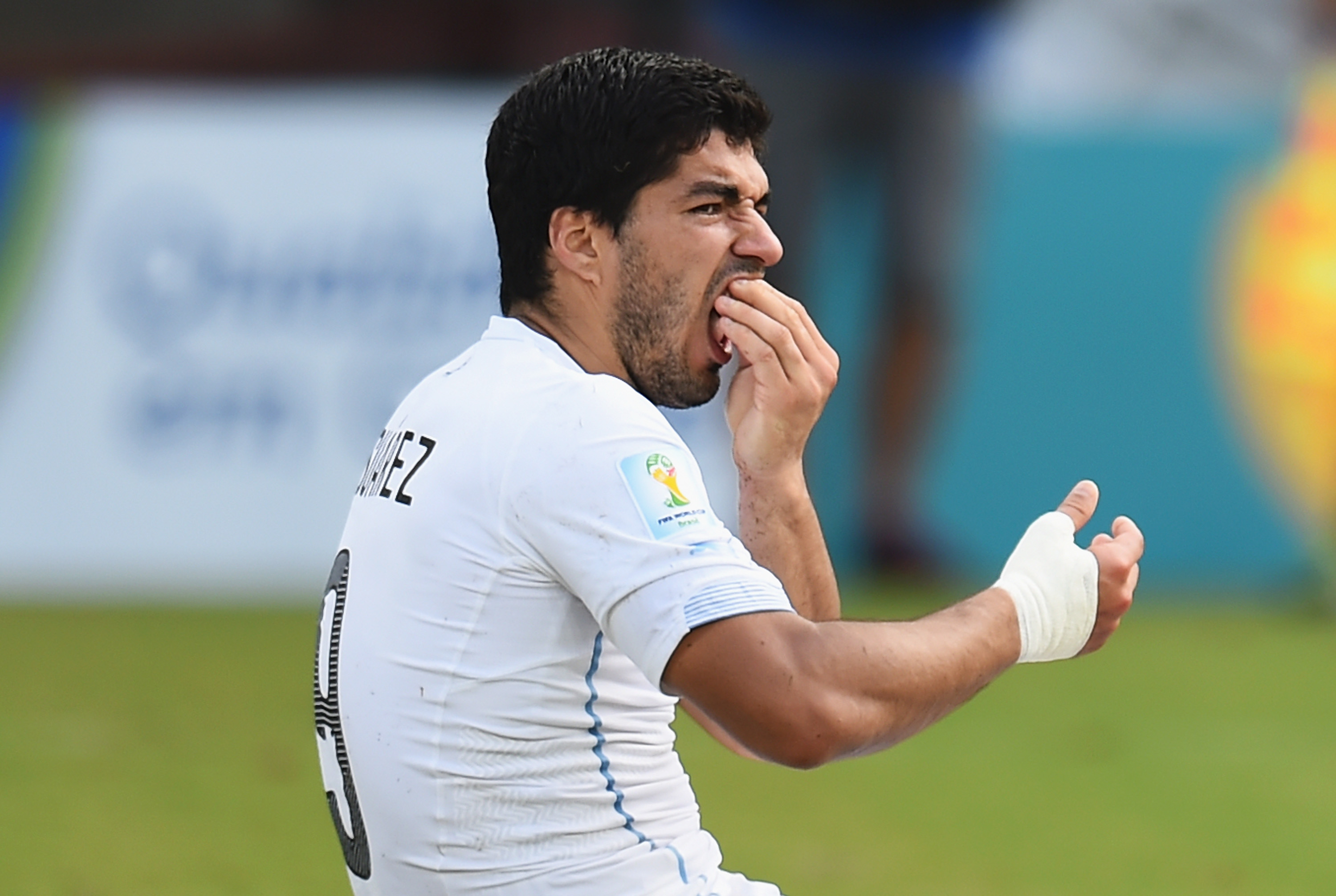 Luis Suarez of Uruguay reacts after biting Giorgio Chiellini of Italy during a 2014 FIFA World Cup match on June 24 in Natal, Brazil. (Shaun Botterill—FIFA/Getty Images)