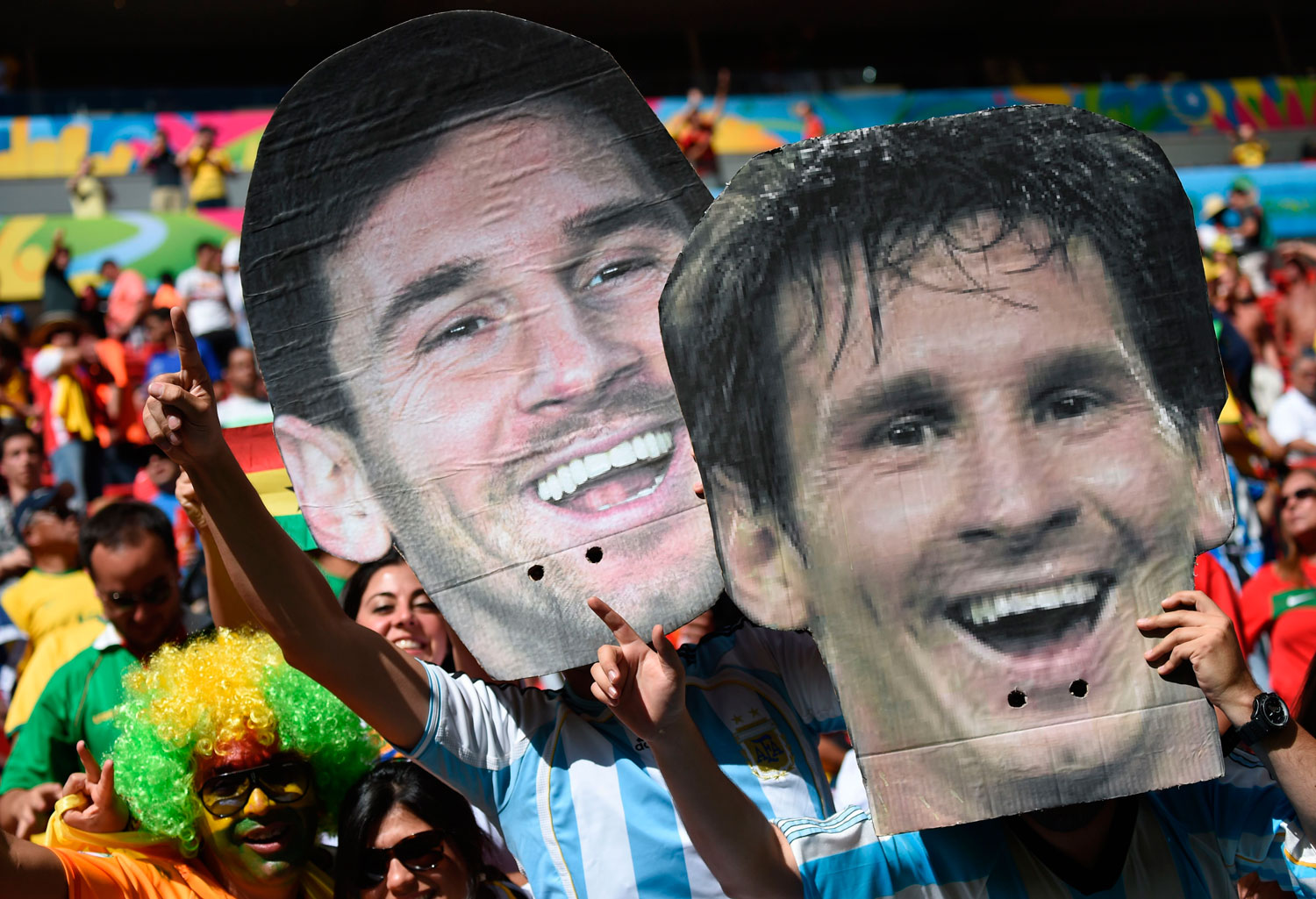 Argentina fans hold up portraits of Argentinian player Lionel Messi during the match between Portugal and Ghana at the Mane Garrincha National Stadium in Brasilia, Brazil on June 26, 2014.