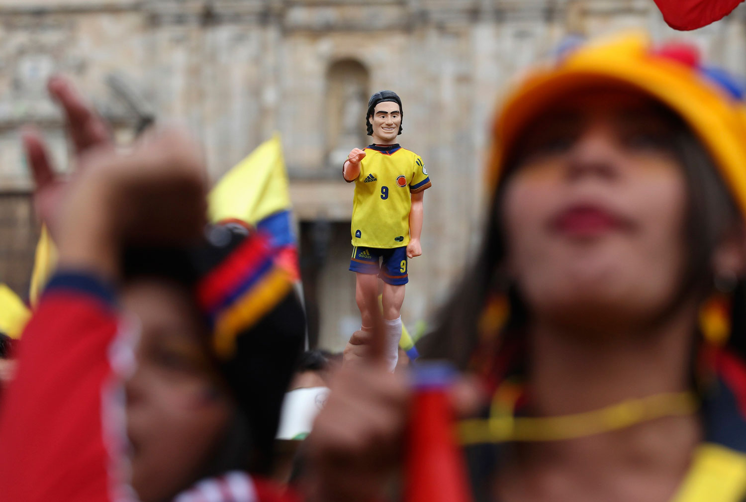Colombia's fans hold a toy figurine of Colombia's national soccer player Falcao as they watch a broadcast of the game between Colombia and Uruguay, at Bolivar Square in Bogota on June 28, 2014.