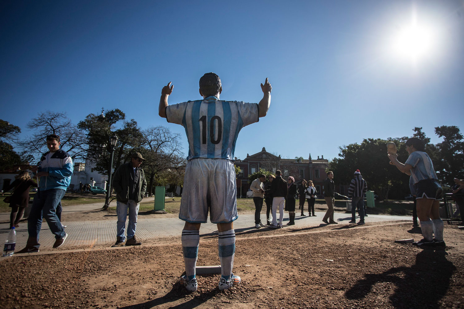 Tourists walk past sculptures of Argentinean players Diego Maradona and player Lionel Messi of Argentina's national soccer team, in the Intendant Alvear Square in Buenos Aires, Argentina on June 19, 2014.