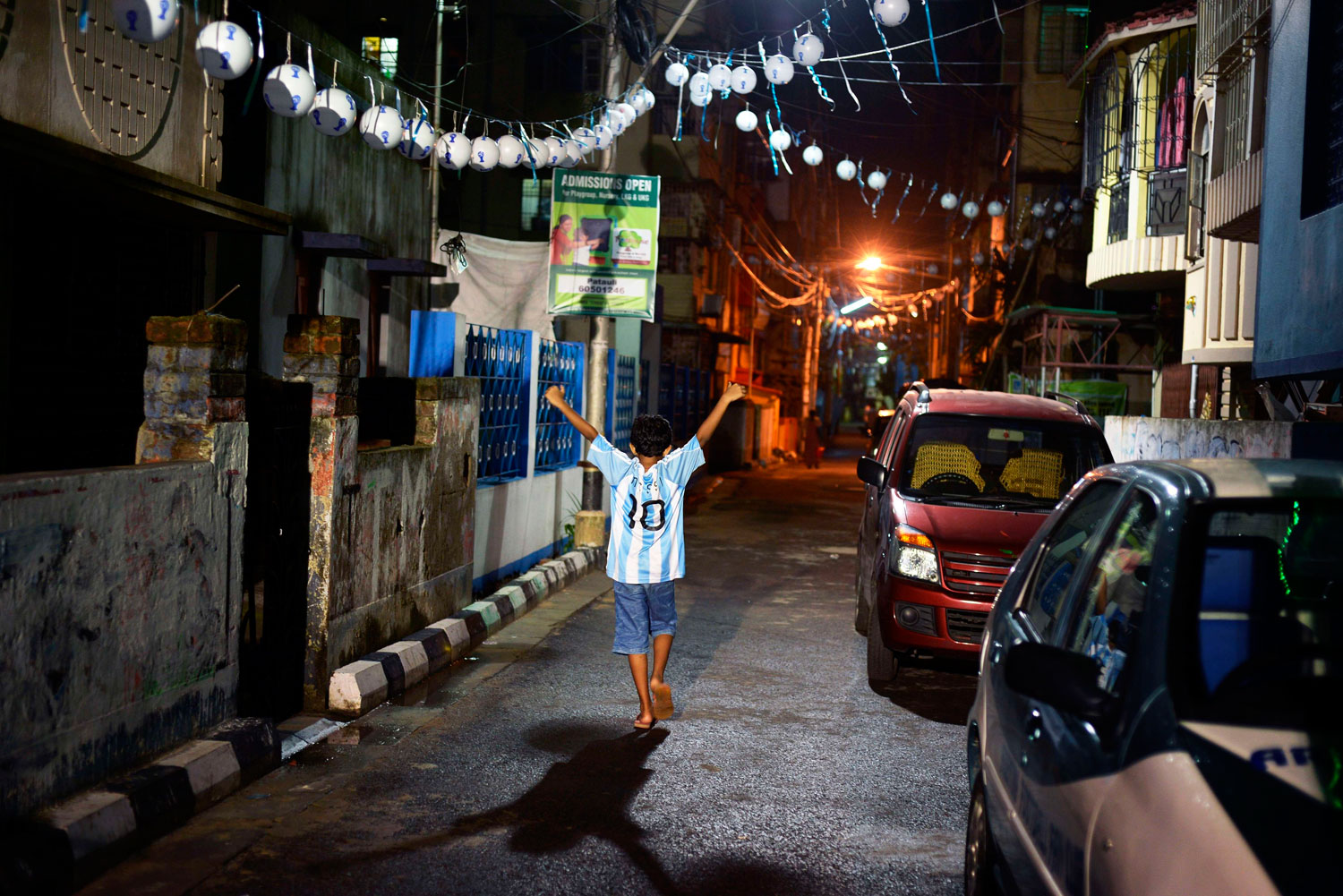 A young Indian football fan of Argentina in a Lionel Messi shirt walks back home after watching the Argentina-Iran match on a giant screen in Kolkata.