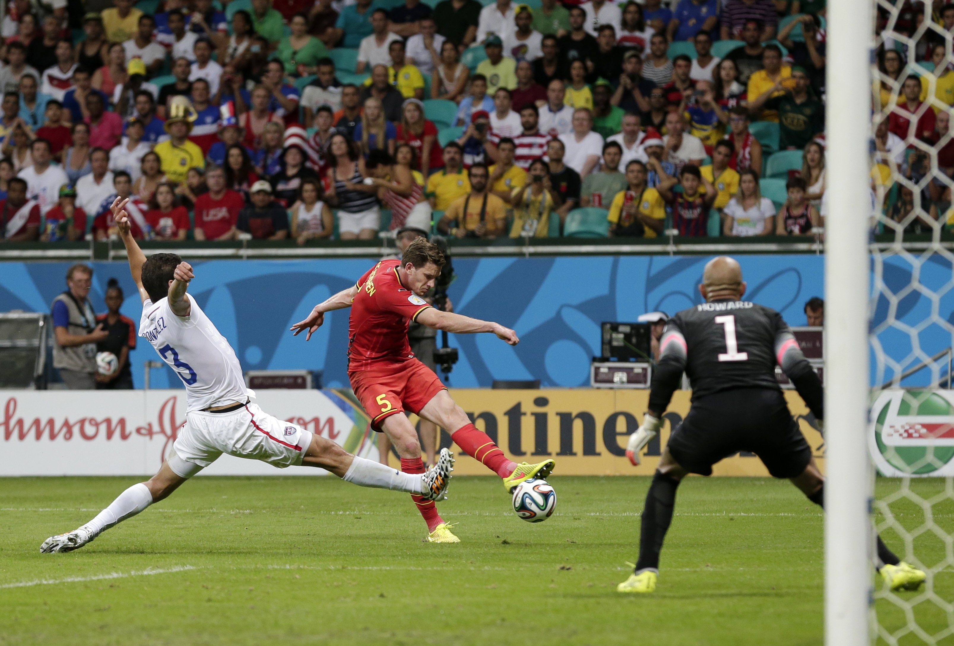 United States' Omar Gonzalez (3) tries to defend as Belgium's Jan Vertonghen gets a shot on United States' goalkeeper Tim Howard during the World Cup round of 16 soccer match between Belgium and the USA at the Arena Fonte Nova in Salvador, Brazil, Tuesday, July 1, 2014. (AP Photo/Marcio Jose Sanchez)