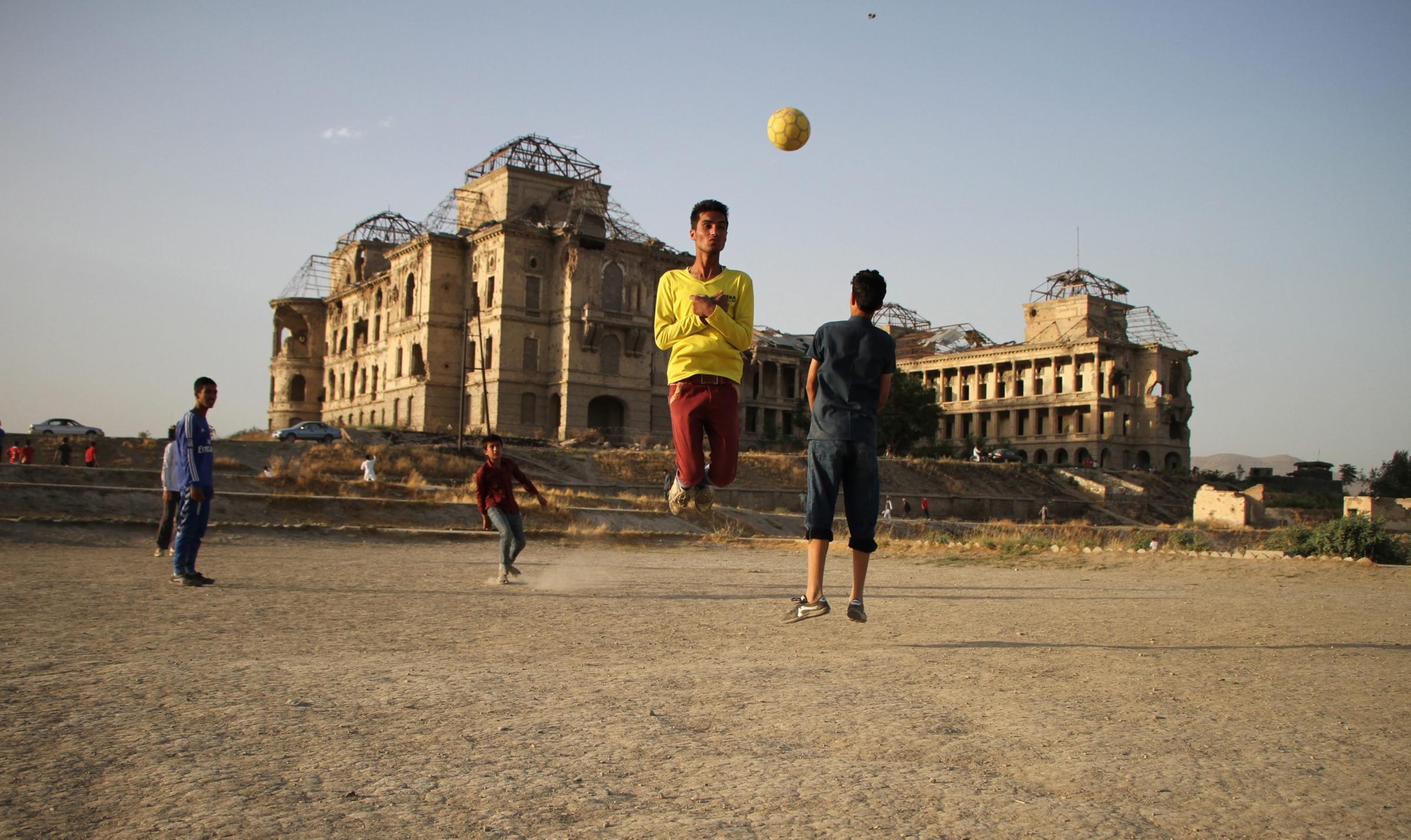 Afghans play soccer on the outskirts of Kabul
