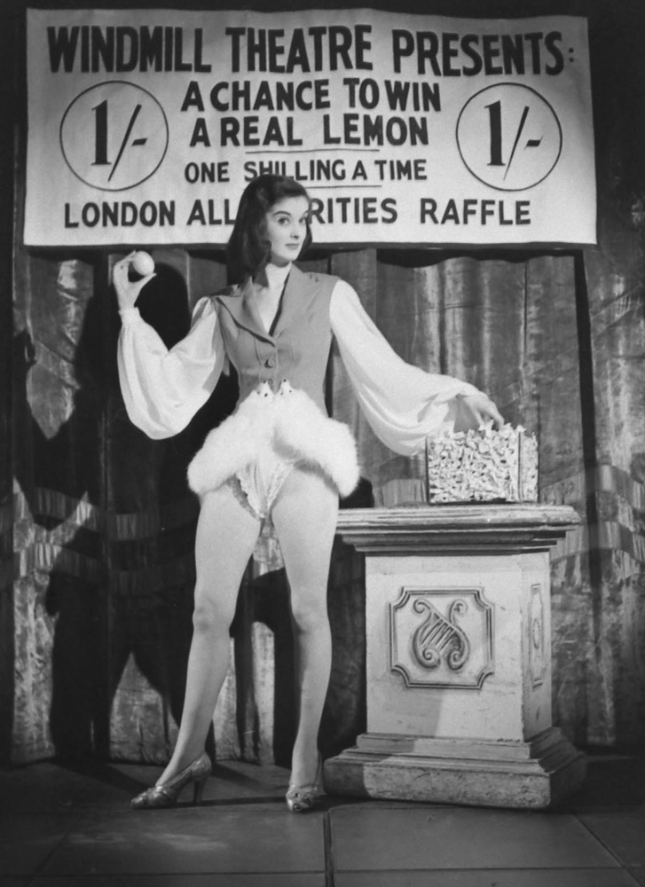 In the midst of a wartime lemon shortage, a woman "auctions off" a lemon in London, 1944. (The auction was staged by photographer David Scherman.)