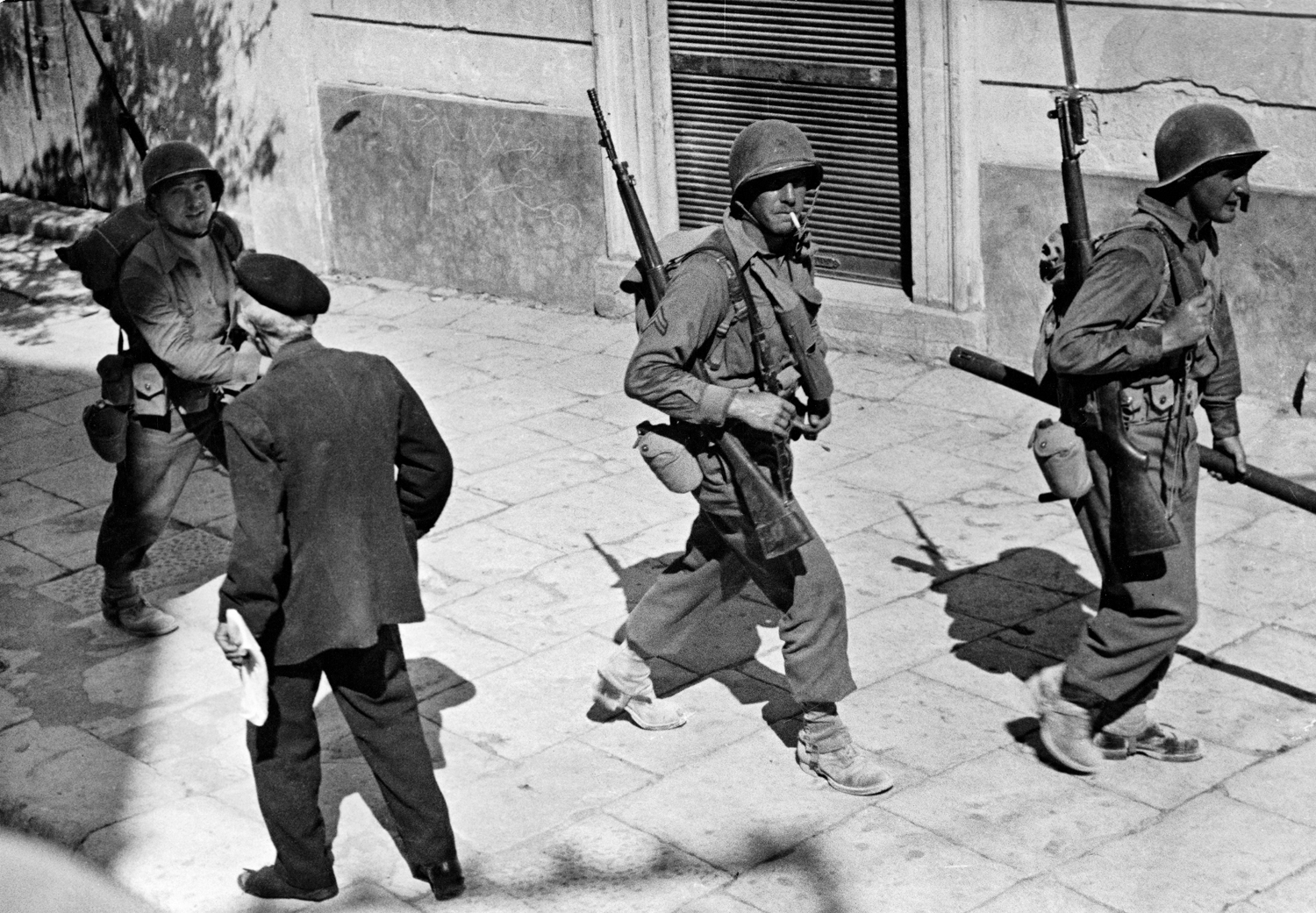 Troops advancing through the streets of Comiso, Sicily, 1943.