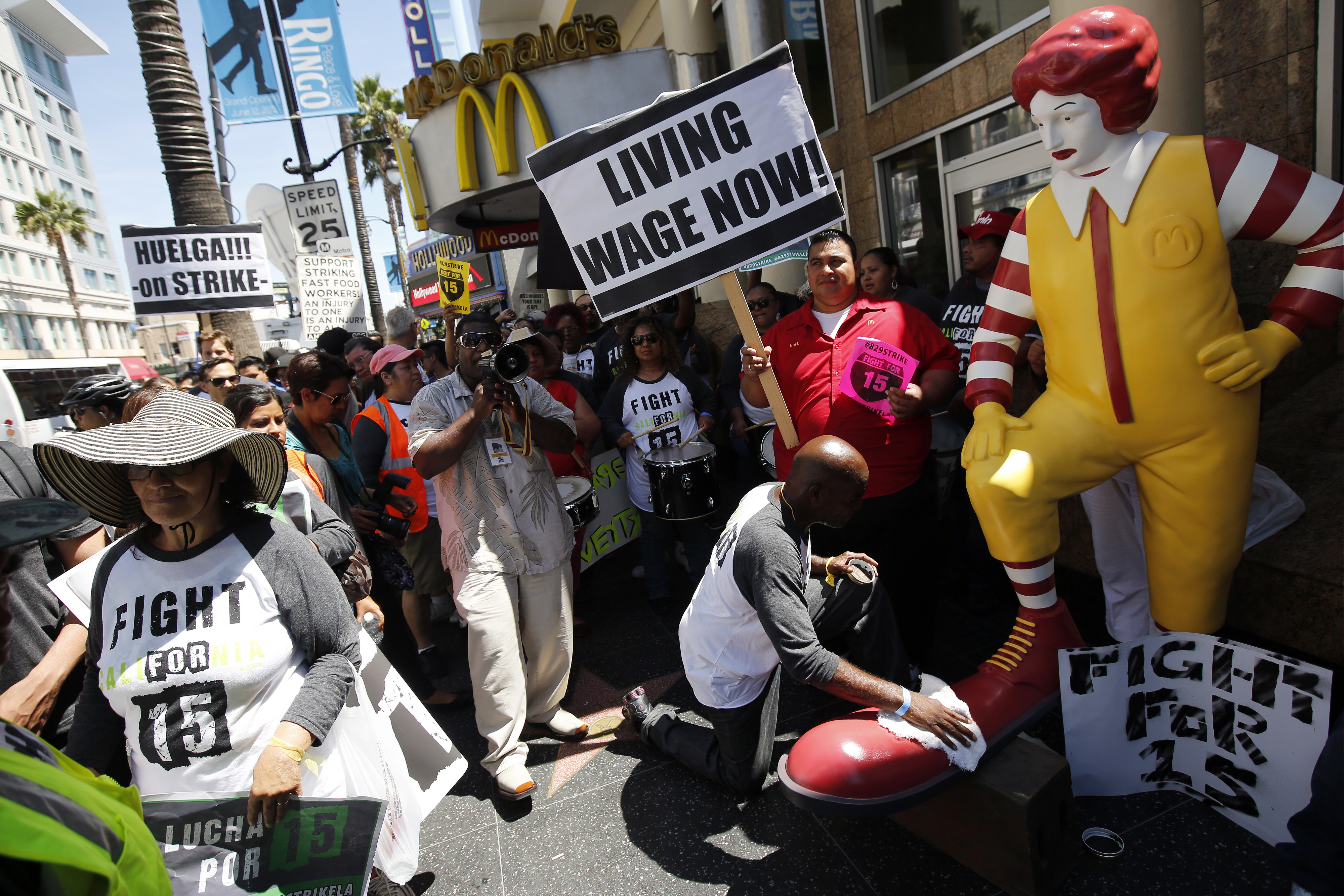 Robert Wideman, a maintenance mechanic at McDonalds Corp., shines the shoes of a Ronald McDonald statue outside of a restaurant while protesting with fast-food workers and supporters organized by the Service Employees International Union (SEIU) in Los Angeles, California, U.S., on Thursday, Aug. 29, 2013. (Bloomberg&mdash;Bloomberg via Getty Images)