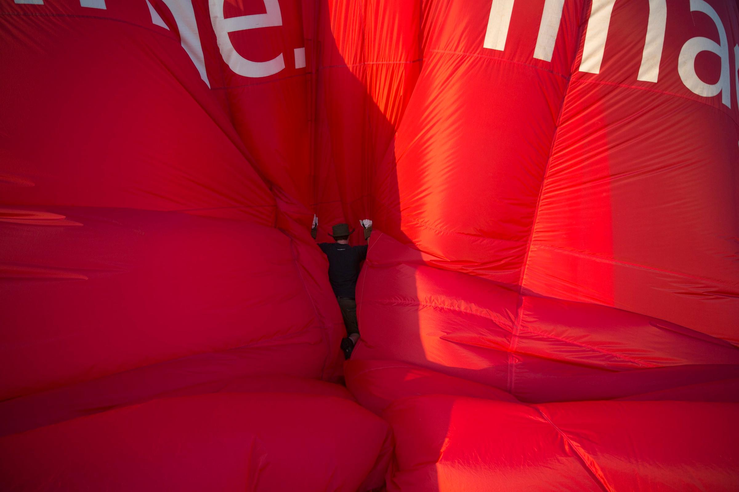 Balloonist checks a balloon as it is deflated at the International Balloon Fiesta near Bristol in western England