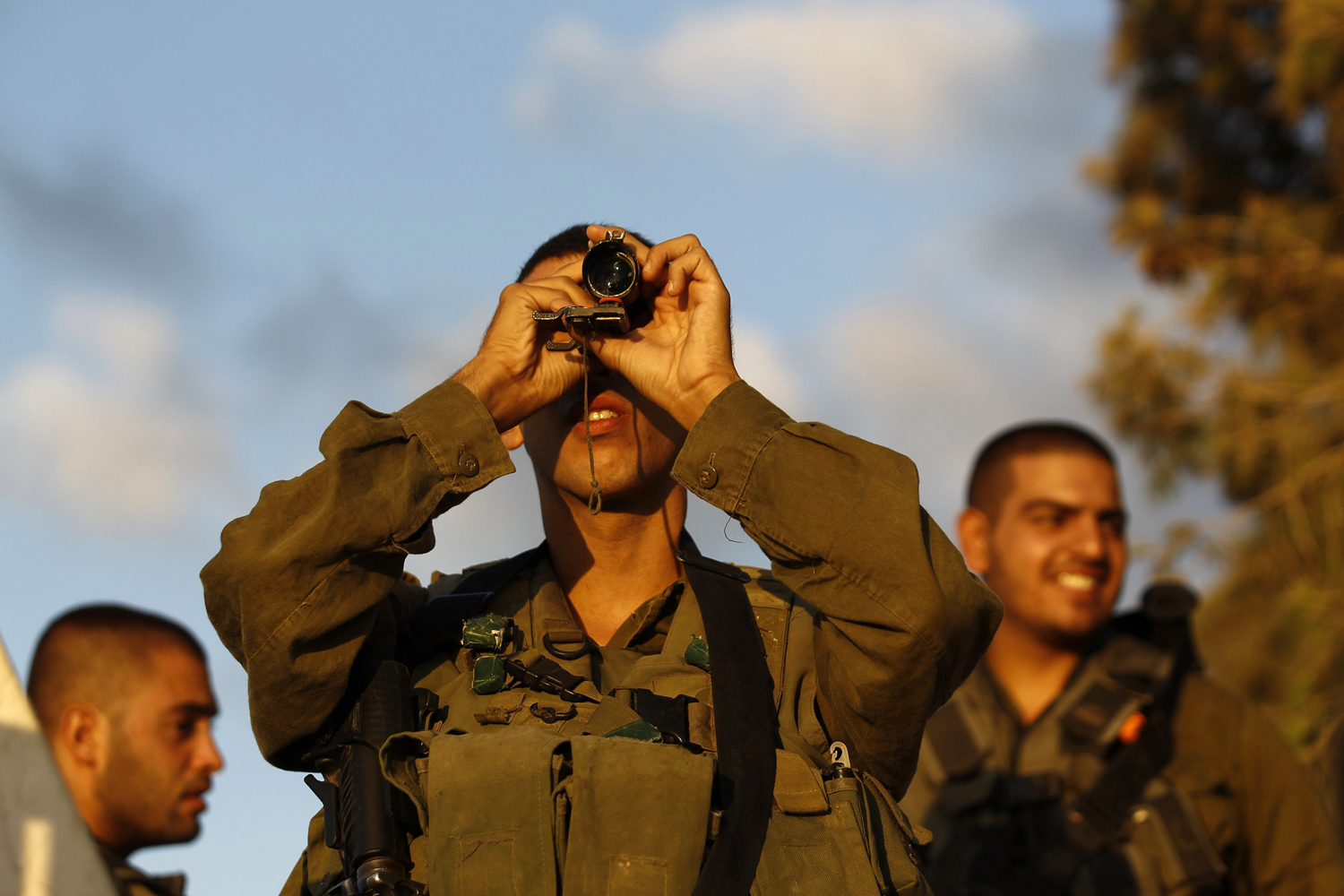 Aug. 9, 2014. An Israeli soldier looks at the Gaza Strip through a monocular on the Israeli border.